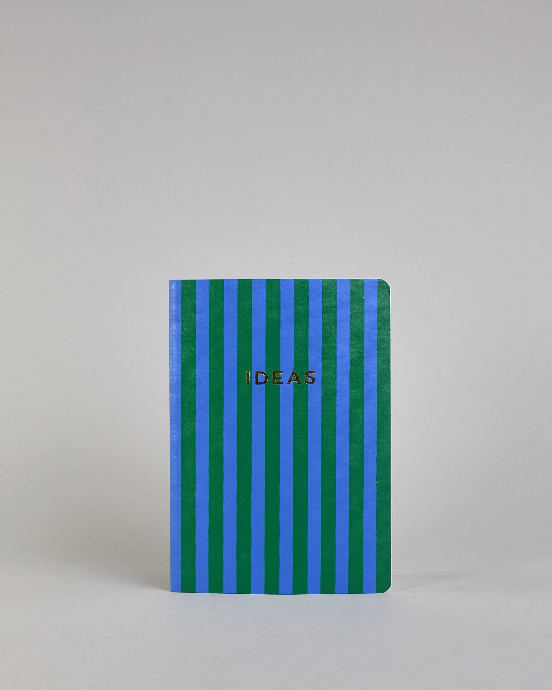 Set aus drei A5-Heften mit recyceltem Baumwolleinband. Die Hefte sind mit senkrechten Streifen in Blau- und Grüntönen gestaltet und zeigen auf dem Cover jeweils ein goldener Spruch: Dreams, Thoughts und Ideas. 30 linierte Seiten innen. #6