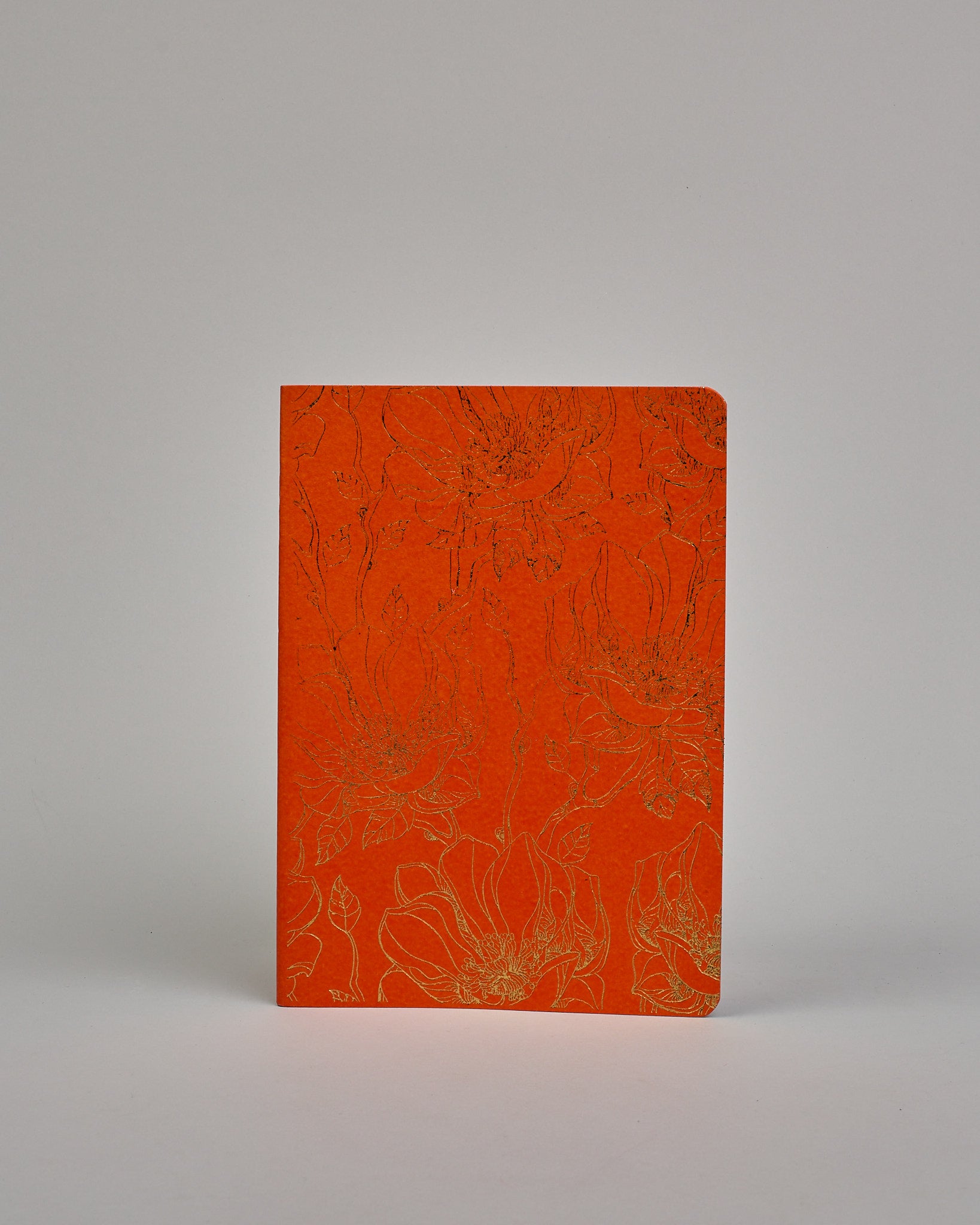 Set bestehend aus drei Heften in magenta, dunkelrot und orange. Jedes hat eine andere Prägung oben Mittig in gold. Das magentafarbene eine Pfingstrose, das dunkelrote einen Zweig mit Blumen, das orangene ein vollflächiges Blumenmuster. Innen sind sie glatt. #4