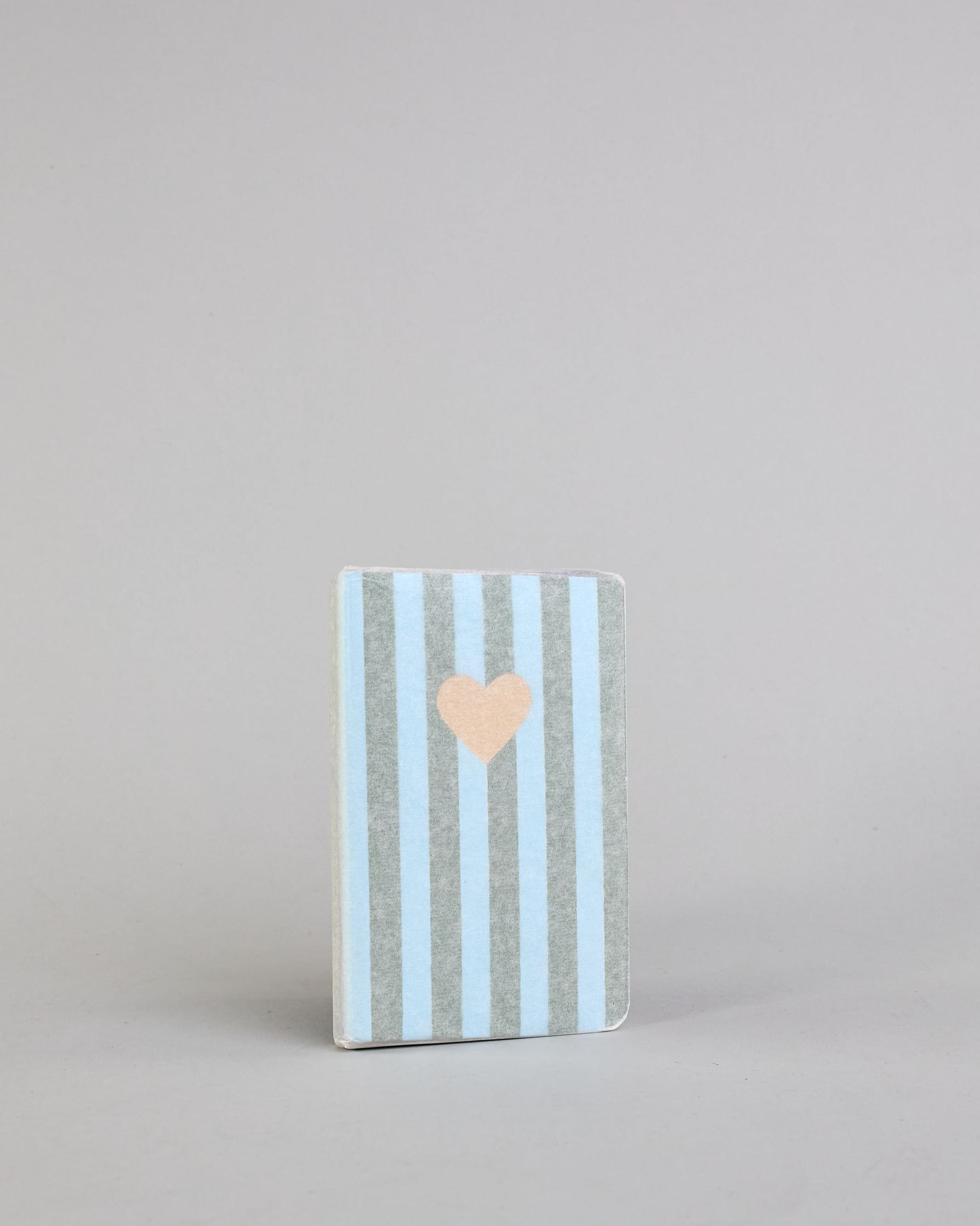 Set aus drei A6-Heften mit recyceltem Baumwolleinband. Die Hefte sind mit senkrechten Streifen in Blau- und Grüntönen gestaltet und zeigen auf dem Cover jeweils ein goldenes Motiv: ein Herz, ein Kleeblatt und eine Libelle. 30 glatte Seiten innen. #9