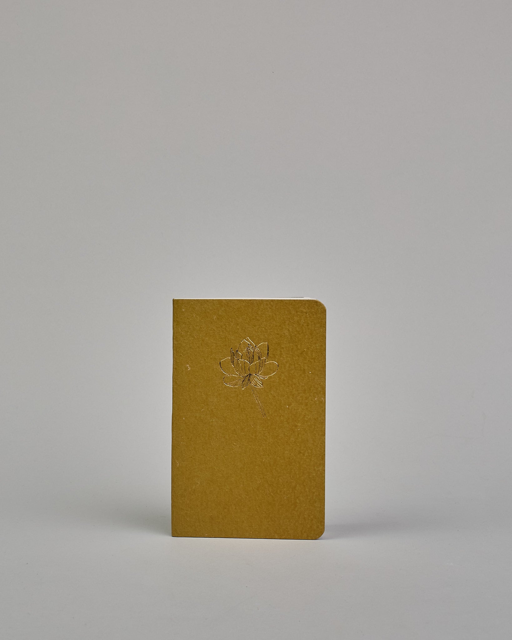 Set bestehend aus drei Heften in dunkelgrün, ockergold und mint. Jedes hat eine andere Prägung oben Mittig in gold. Das dunkelgrüne ein Ginkoblatt, das ockergoldene eine Lotusblume und das mintfarbene eine Pusteblume. Innen sind sie glatt. #4