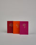 Set bestehend aus drei Heften in magenta, dunkelrot und orange. Jedes hat eine andere Prägung oben Mittig in gold. Das magentafarbene eine Pfingstrose, das dunkelrote eine Rose, das orangene einen Zweig mit Blättern. Innen sind sie glatt. #1