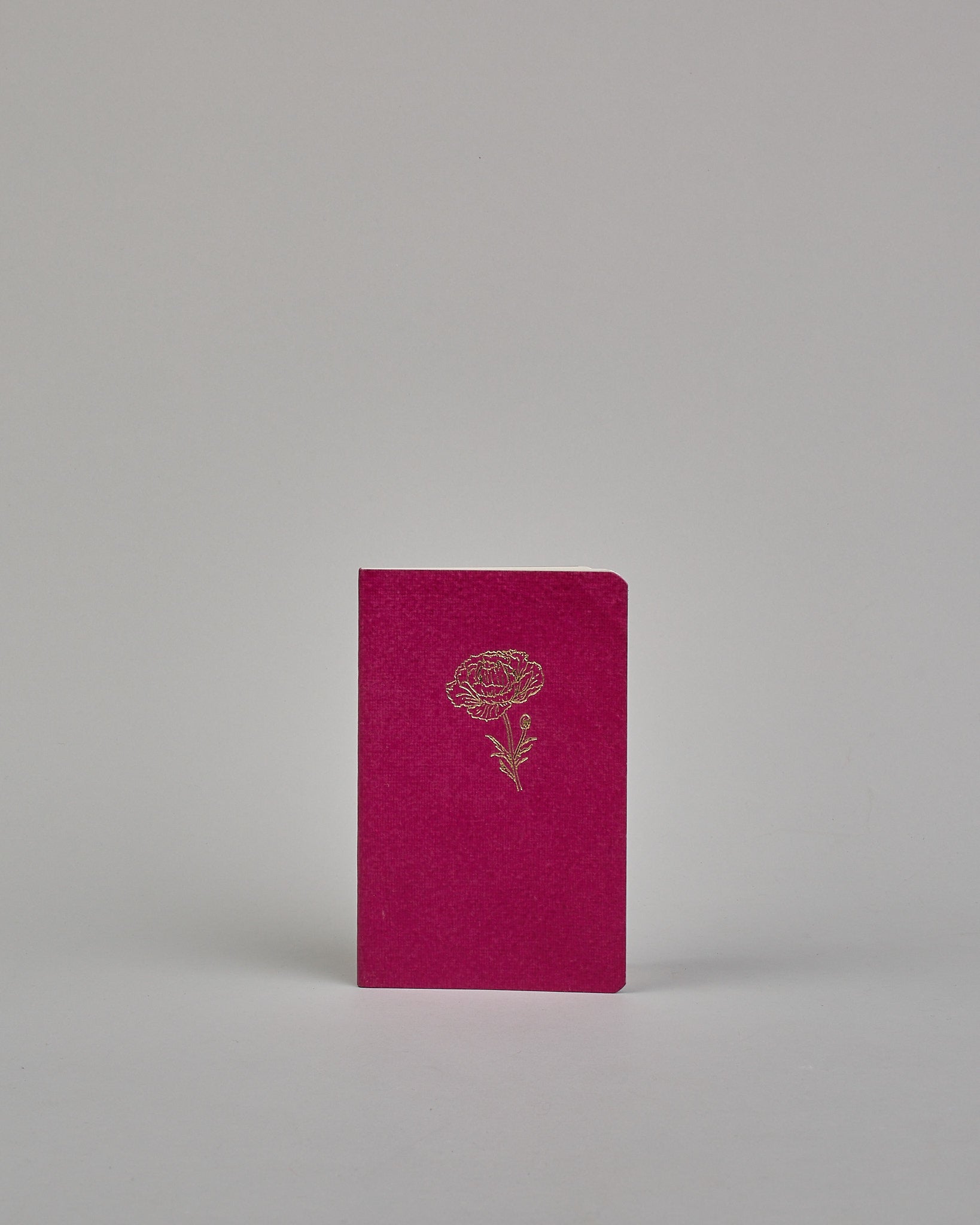 Set bestehend aus drei Heften in magenta, dunkelrot und orange. Jedes hat eine andere Prägung oben Mittig in gold. Das magentafarbene eine Pfingstrose, das dunkelrote eine Rose, das orangene einen Zweig mit Blättern. Innen sind sie glatt. #4