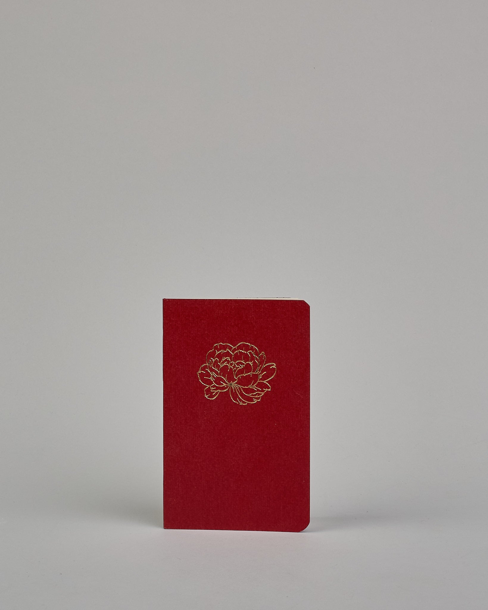 Set bestehend aus drei Heften in magenta, dunkelrot und orange. Jedes hat eine andere Prägung oben Mittig in gold. Das magentafarbene eine Pfingstrose, das dunkelrote eine Rose, das orangene einen Zweig mit Blättern. Innen sind sie glatt. #6