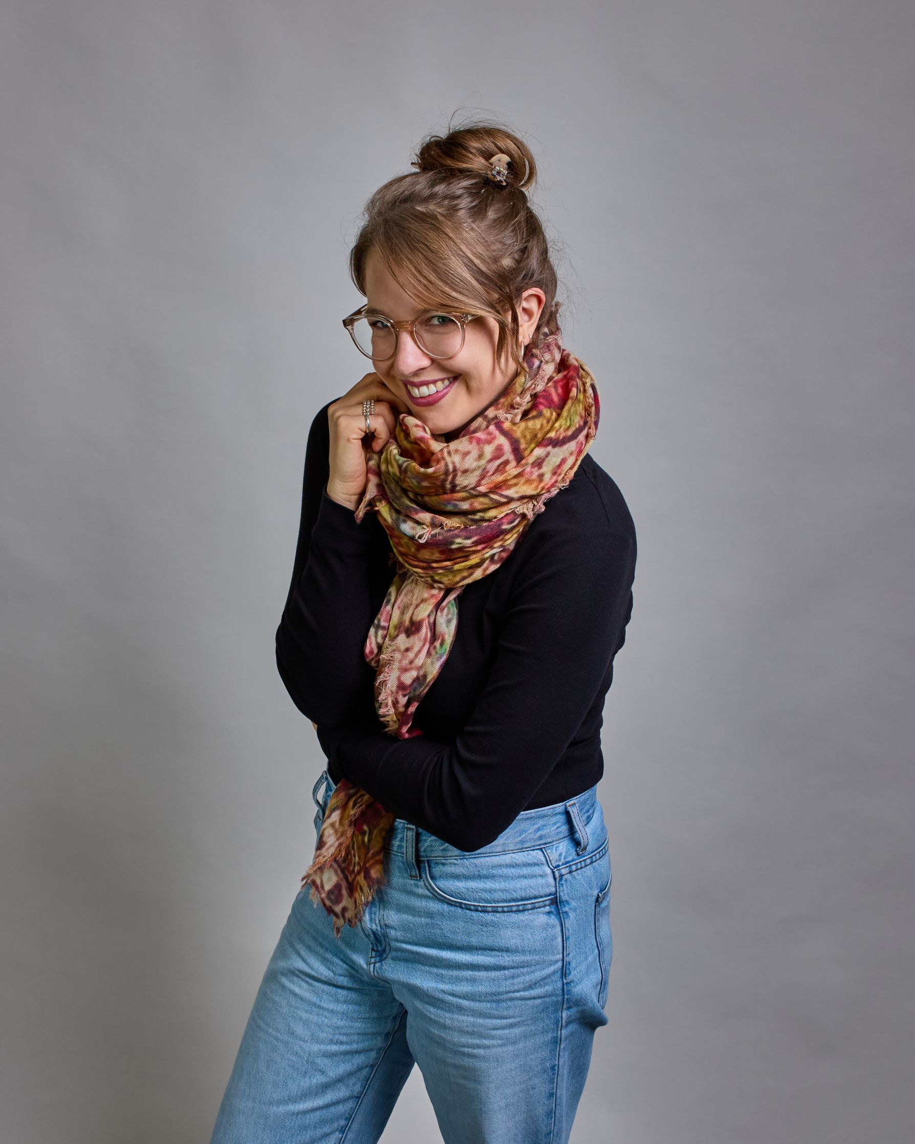 Ein Schal aus 75 % Wolle und 25 % Modal mit den Maßen 100 × 180 cm. Je nach Bild ist er locker um den Nacken gelegt oder einmal gewickelt, um eine lockere Schlaufe um den Hals zu haben, oder zweimal gewickelt, um das Maximum an Wärme zu bekommen. An den Kanten ist er leicht gefranst. Das Muster des Schals ist orientalisch inspiriert und besteht aus unterschiedlichen Ornamenten in verschiedenen Beige- beziehungsweise Gelb- oder Brauntönen und Akzenten aus Pink- Grün-, und Türkistönen. #4