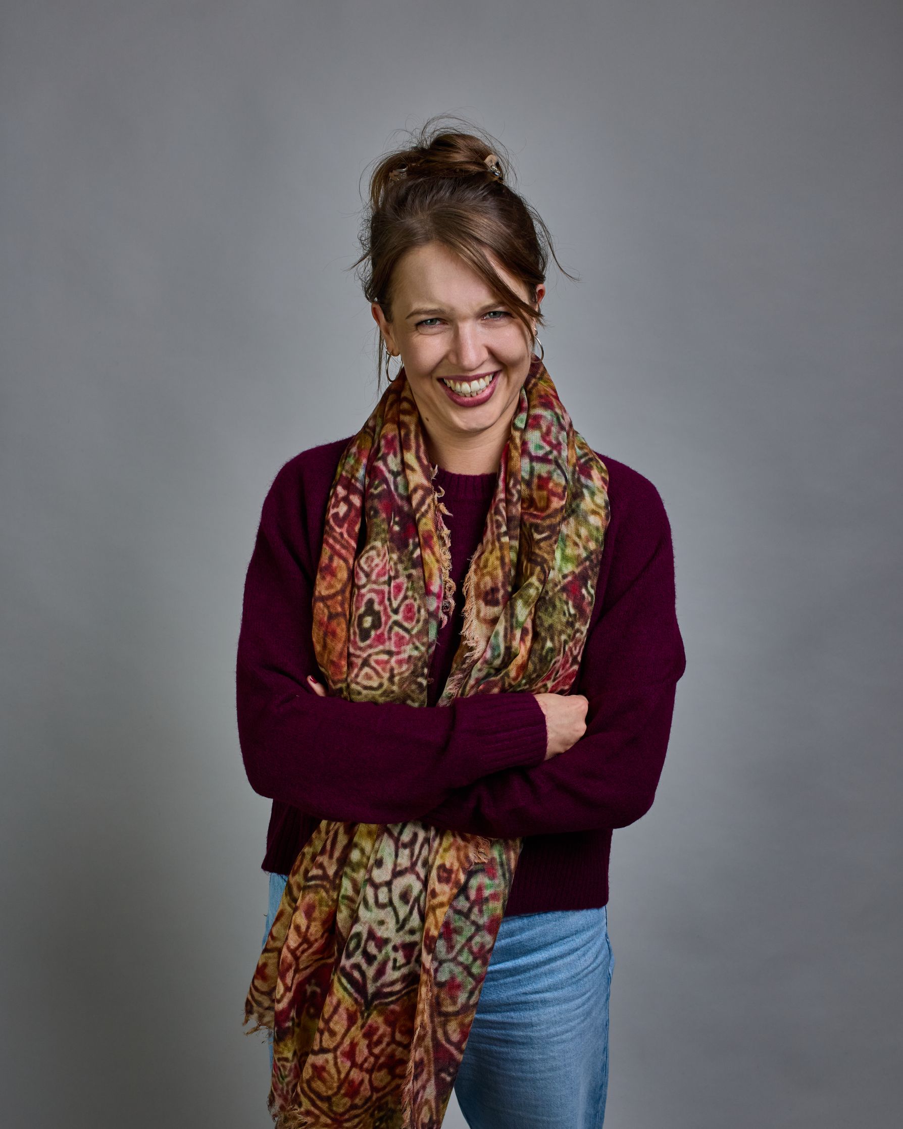 Ein Schal aus 75 % Wolle und 25 % Modal mit den Maßen 100 × 180 cm. Je nach Bild ist er locker um den Nacken gelegt oder einmal gewickelt, um eine lockere Schlaufe um den Hals zu haben, oder zweimal gewickelt, um das Maximum an Wärme zu bekommen. An den Kanten ist er leicht gefranst. Das Muster des Schals ist orientalisch inspiriert und besteht aus unterschiedlichen Ornamenten in verschiedenen Beige- beziehungsweise Gelb- oder Brauntönen und Akzenten aus Pink- Grün-, und Türkistönen. #8