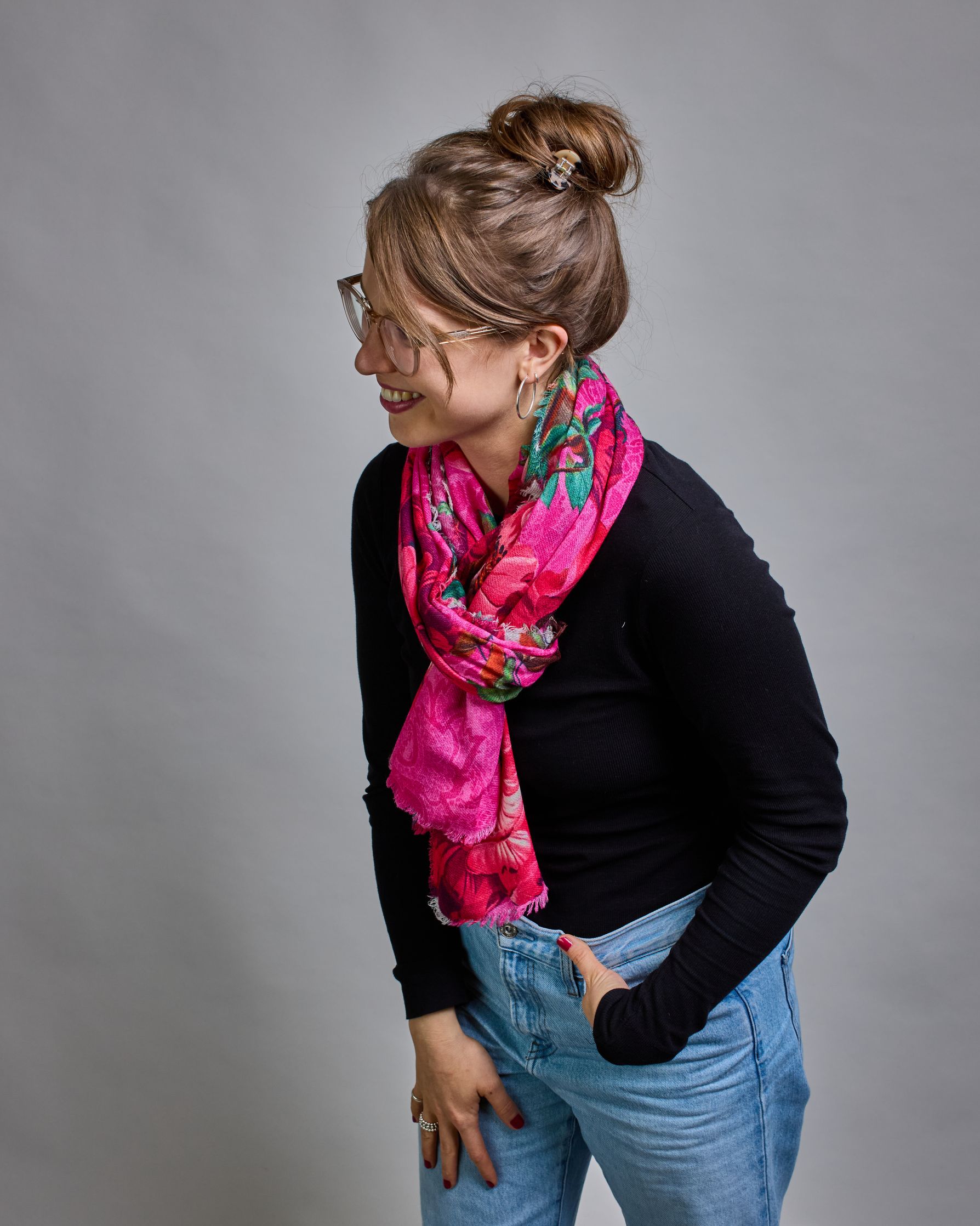 Ein Schal aus 75 % Wolle und 25 % Modal mit den Maßen 70 × 180 cm. Je nach Bild ist er locker um den Nacken gelegt oder einmal gewickelt, um eine lockere Schlaufe um den Hals zu haben, oder zweimal gewickelt, um das Maximum an Wärme zu bekommen. An den Kanten ist er leicht gefranst. Die Hintergrundfarbe des Schals ist pink. Auf dem ganzen Schal sind Blumen in Rot-, und Pinktönen sowie Blätter beziehungsweise Blumenstängel in verschiedenen Grüntönen verteilt. #2