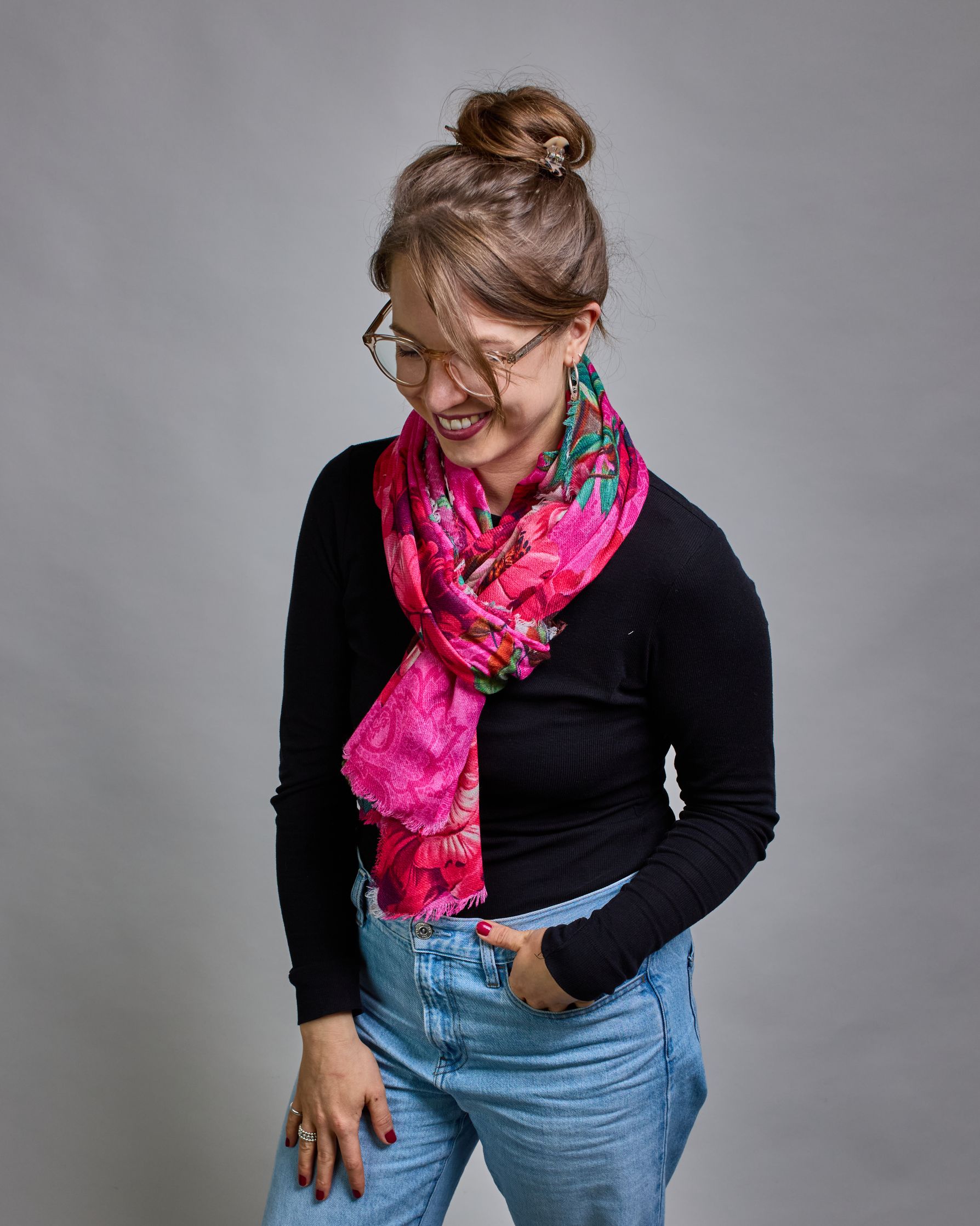 Ein Schal aus 75 % Wolle und 25 % Modal mit den Maßen 70 × 180 cm. Je nach Bild ist er locker um den Nacken gelegt oder einmal gewickelt, um eine lockere Schlaufe um den Hals zu haben, oder zweimal gewickelt, um das Maximum an Wärme zu bekommen. An den Kanten ist er leicht gefranst. Die Hintergrundfarbe des Schals ist pink. Auf dem ganzen Schal sind Blumen in Rot-, und Pinktönen sowie Blätter beziehungsweise Blumenstängel in verschiedenen Grüntönen verteilt. #3