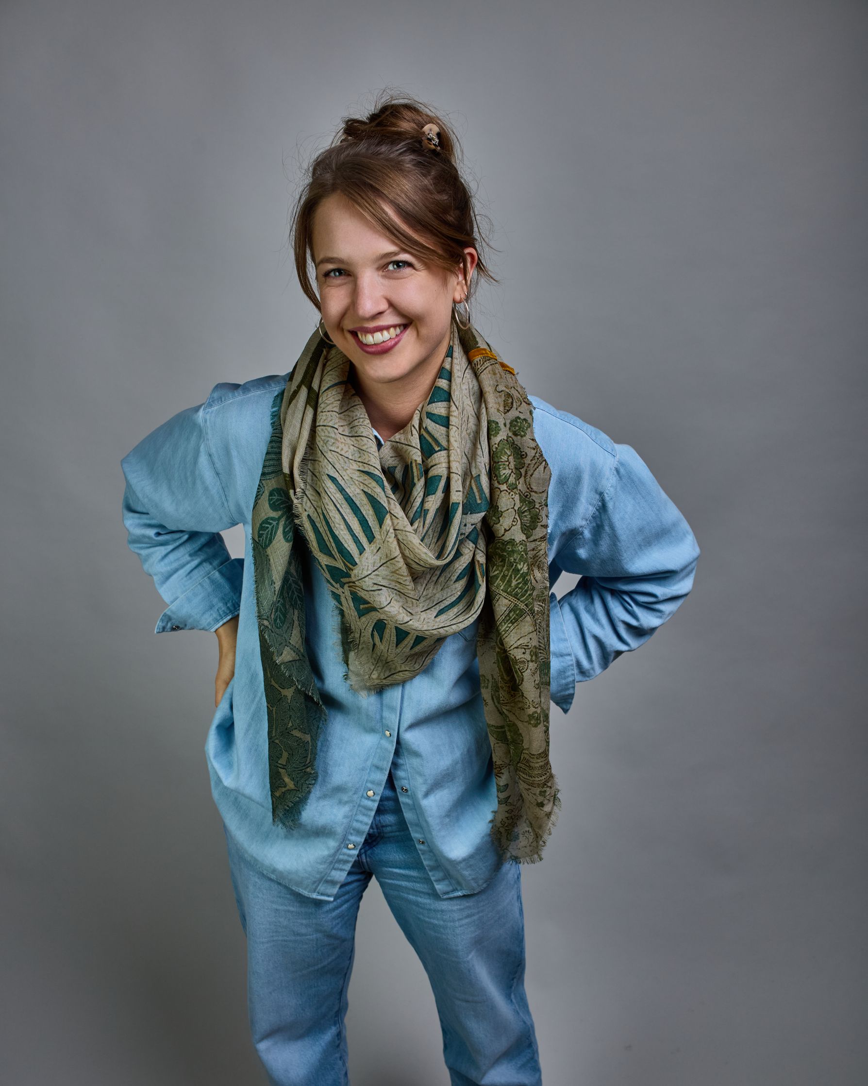 Ein Schal aus 90 % Wolle und 10% Seide. Je nach Bild ist er locker um den Nacken gelegt oder einmal gewickelt, um eine lockere Schlaufe um den Hals zu haben, oder zweimal gewickelt, um das Maximum an Wärme zu bekommen. An den Kanten ist er leicht gefranst. Das Design ist in 4 gleichgroße Quadrate aufgeteilt die jeweils ein anderes Muster hat. Die Quadrate sind mit einem aufgenähtem Okkerfarbenen Samtband unterteilt. Eines der Quadrate hat als Grundfarbe Cremeweiß und darauf befinden sich in verschiedenen G…