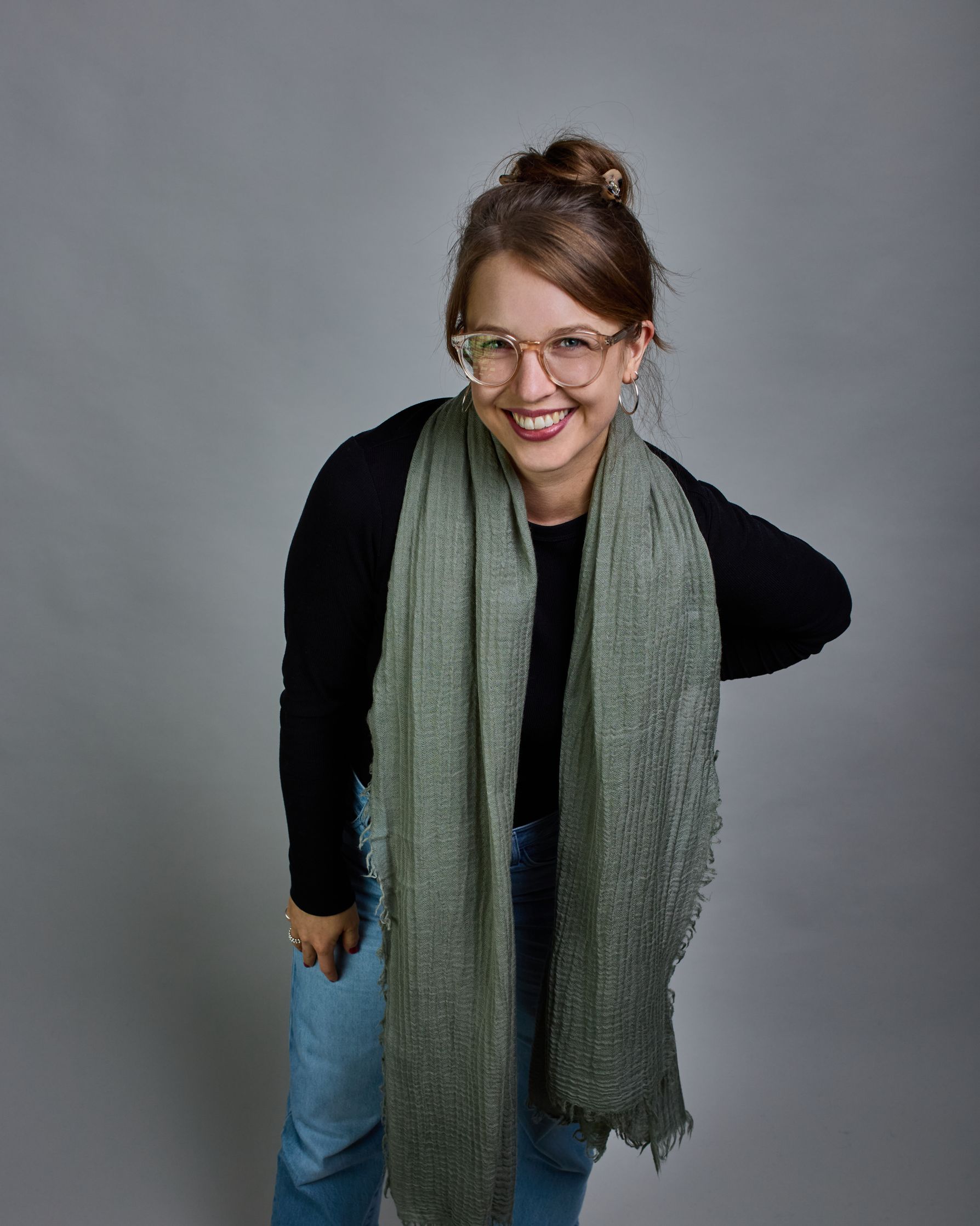 Ein hellgrüner Schal aus 100 % Wolle mit den Maßen 100x180 cm. Je nach Bild ist er locker um den Hals gelegt oder einmal gewickelt, um eine Schlaufe um den Hals zu haben. Der Schal ist einfärbig und hat an den Kanten leichte Fransen. Die organische Struktur verleiht dem Schal ein lässiges, zeitloses Design. #2