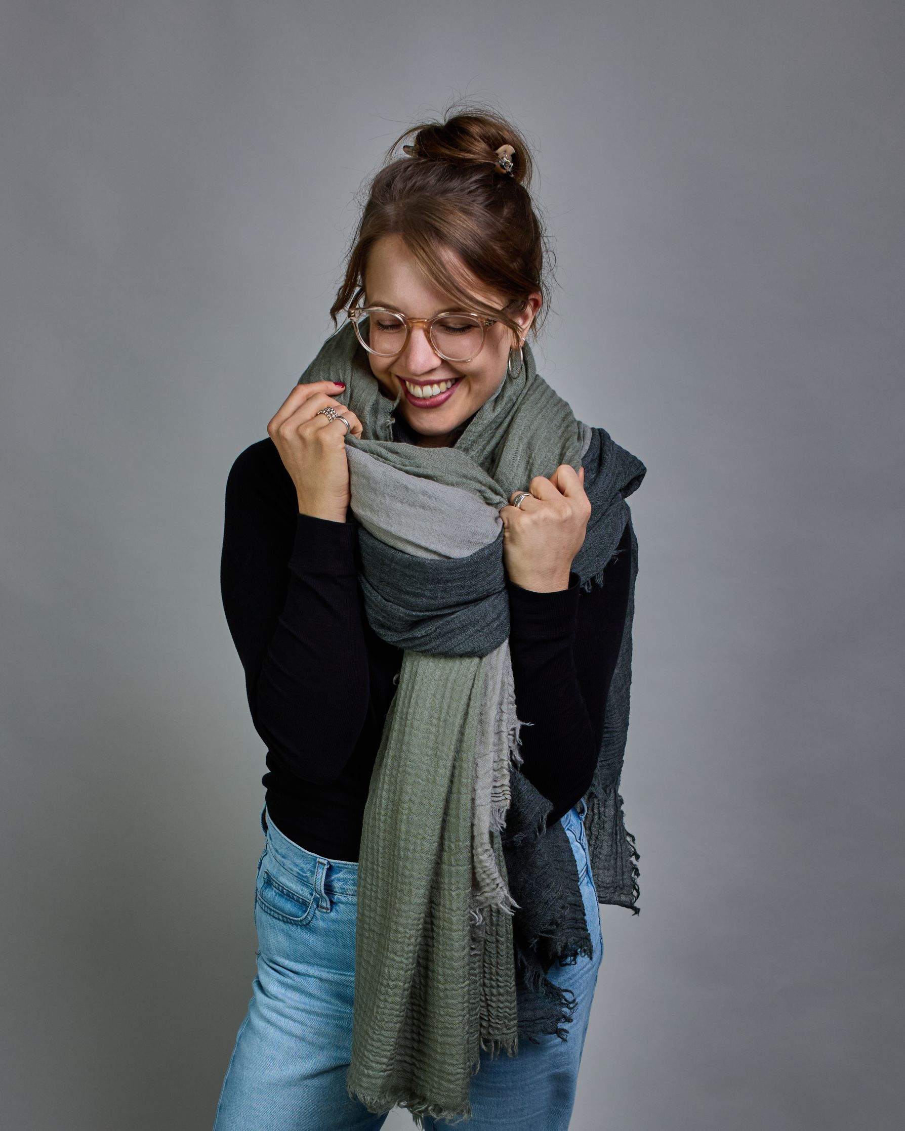 Ein hellgrüner Schal aus 100 % Wolle mit den Maßen 100x180 cm. Je nach Bild ist er locker um den Hals gelegt oder einmal gewickelt, um eine Schlaufe um den Hals zu haben. Der Schal ist einfärbig und hat an den Kanten leichte Fransen. Die organische Struktur verleiht dem Schal ein lässiges, zeitloses Design. #5