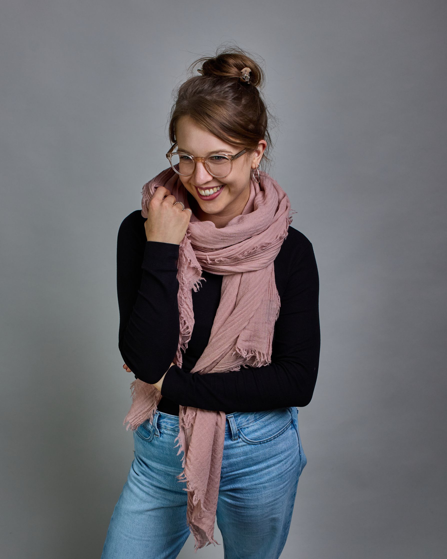 Ein rosafarbener Schal aus 100 % Wolle mit den Maßen 100x180 cm. Je nach Bild ist er locker um den Hals gelegt oder einmal gewickelt, um eine Schlaufe um den Hals zu haben. Der Schal ist einfärbig und hat an den Kanten leichte Fransen. Die organische Struktur verleiht dem Schal ein lässiges, zeitloses Design. #2