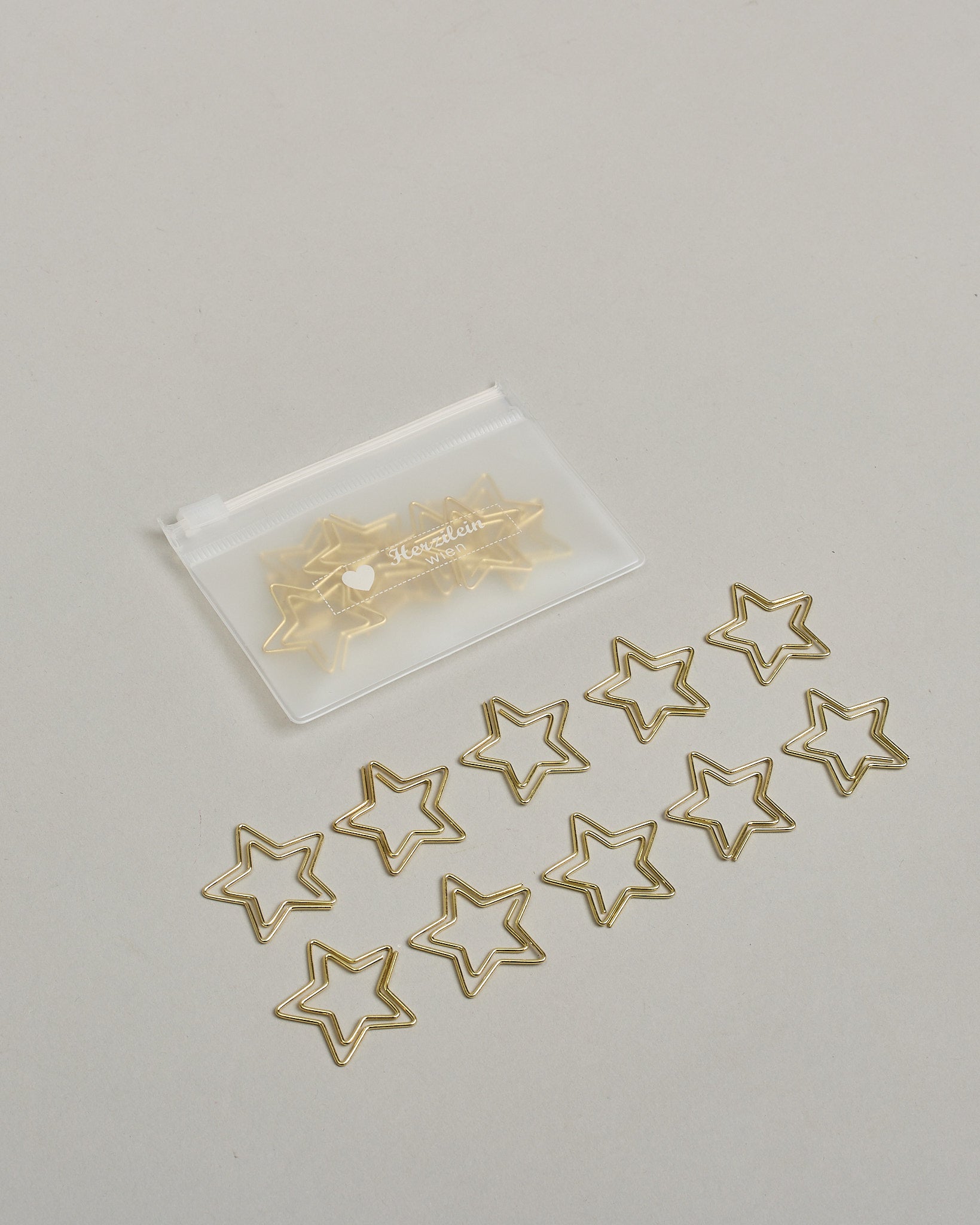 Zehn Büroklammern in Form von Sternen aus goldenem Draht. Sie kommen in einer kleinen Silikonverpackung. #2