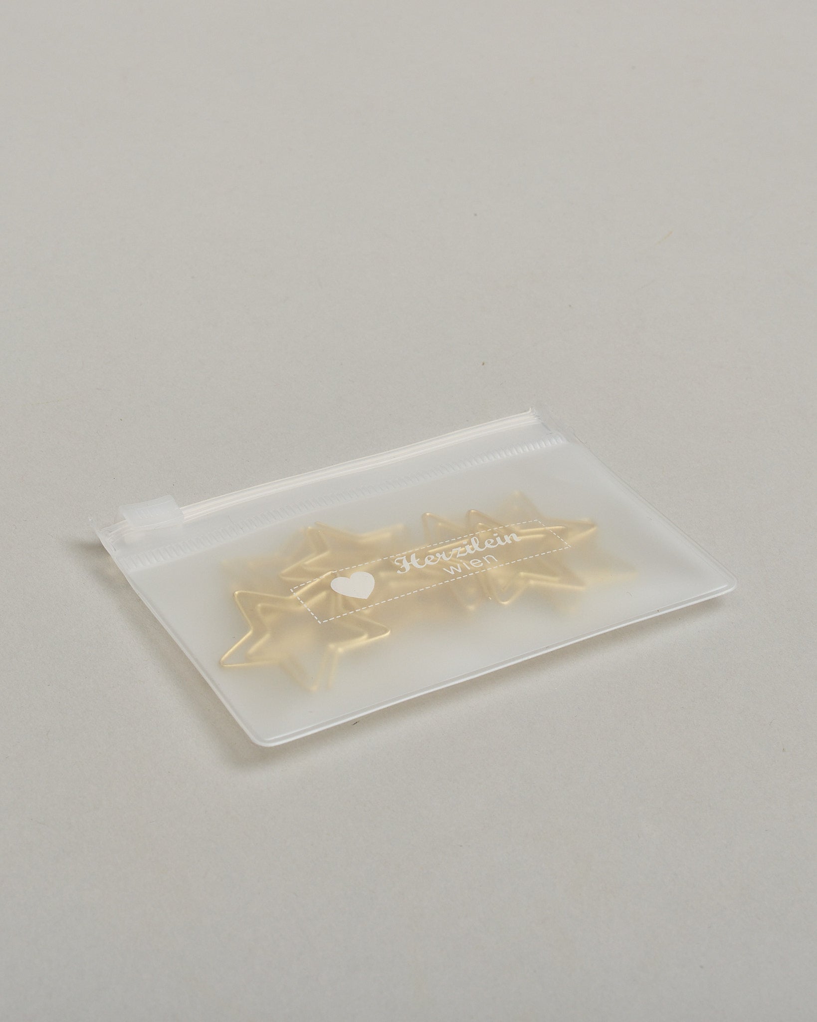 Zehn Büroklammern in Form von Sternen aus goldenem Draht. Sie kommen in einer kleinen Silikonverpackung. #3