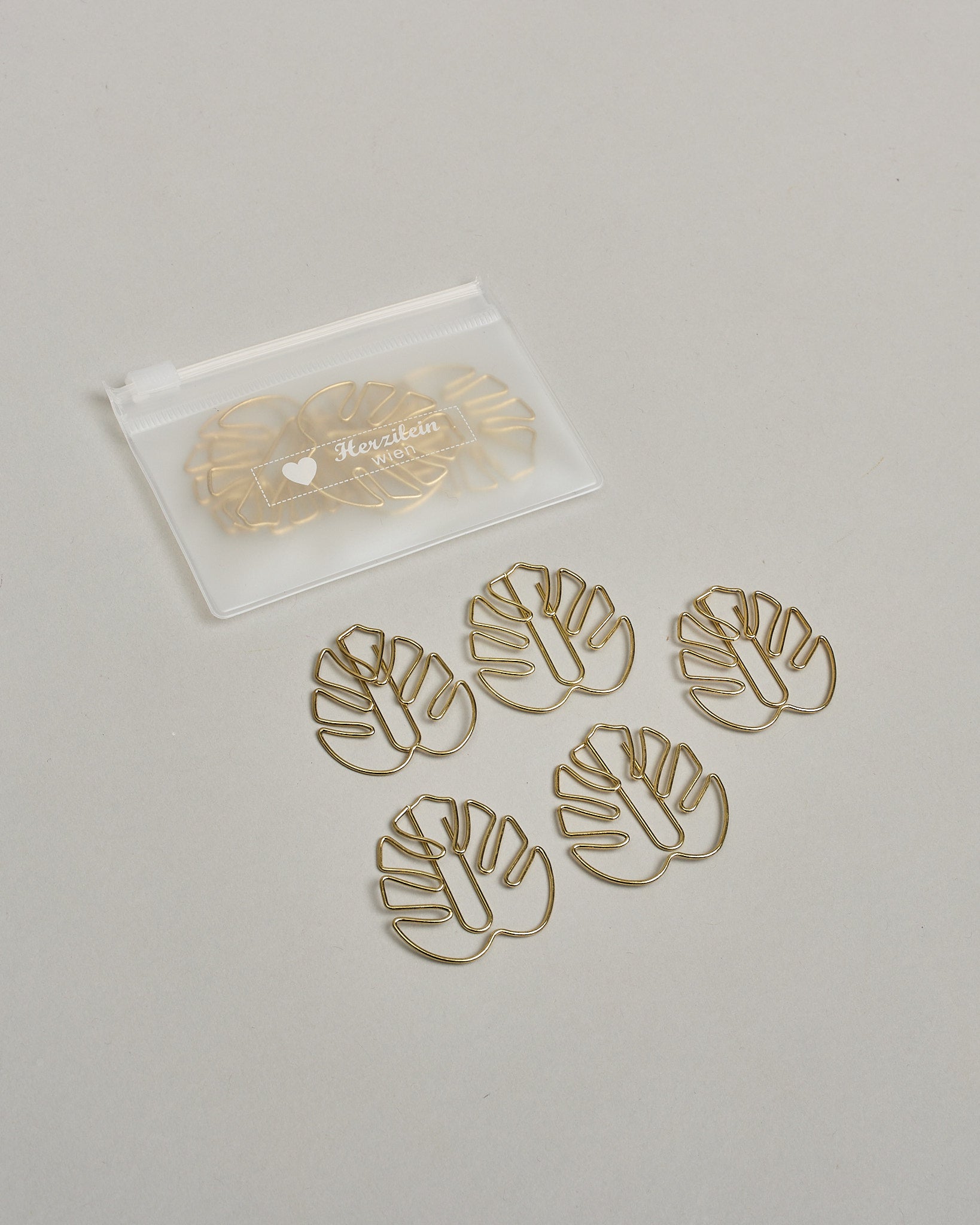 Büroklammern in Form von Monsterablättern aus goldenem Draht. Sie kommen in einer kleinen Silikonverpackung. #2
