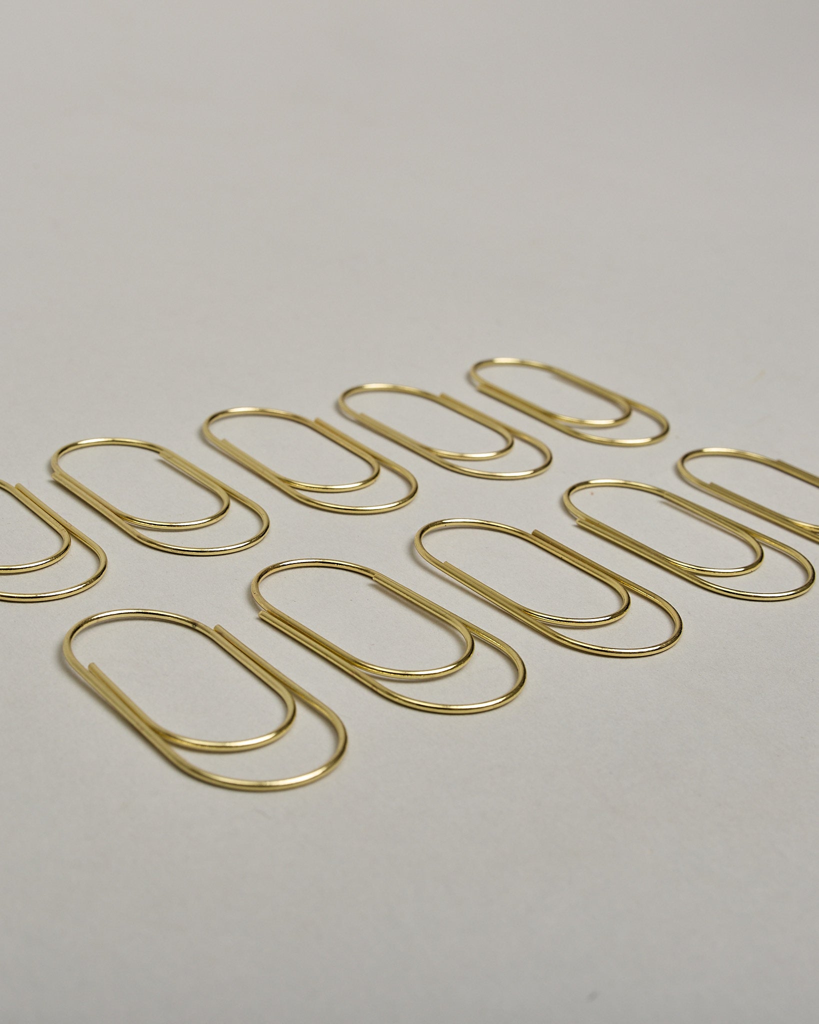 Büroklammern in bauchiger Form aus goldenem Draht. Sie kommen in einer kleinen Silikonverpackung. #1