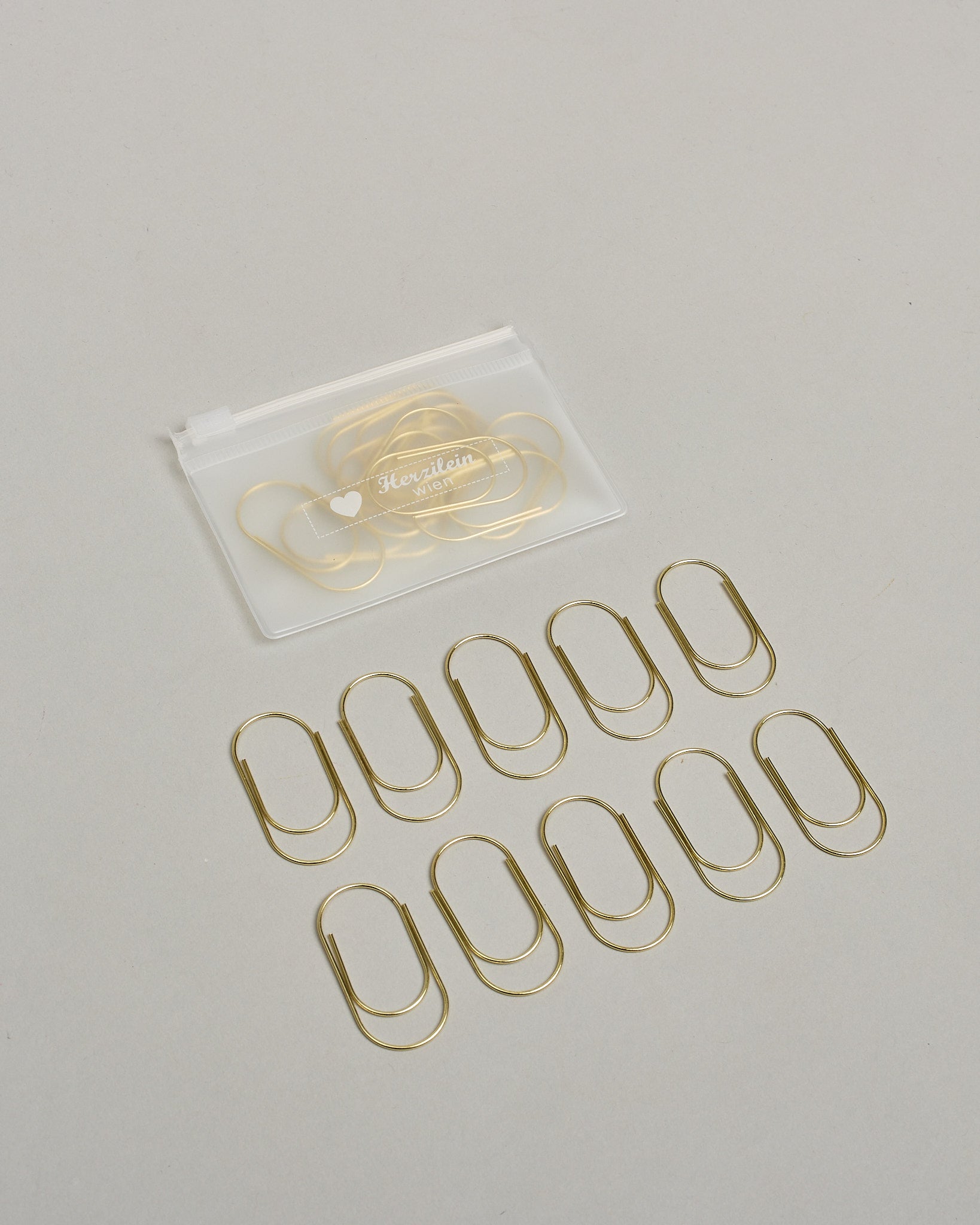 Büroklammern in bauchiger Form aus goldenem Draht. Sie kommen in einer kleinen Silikonverpackung. #2