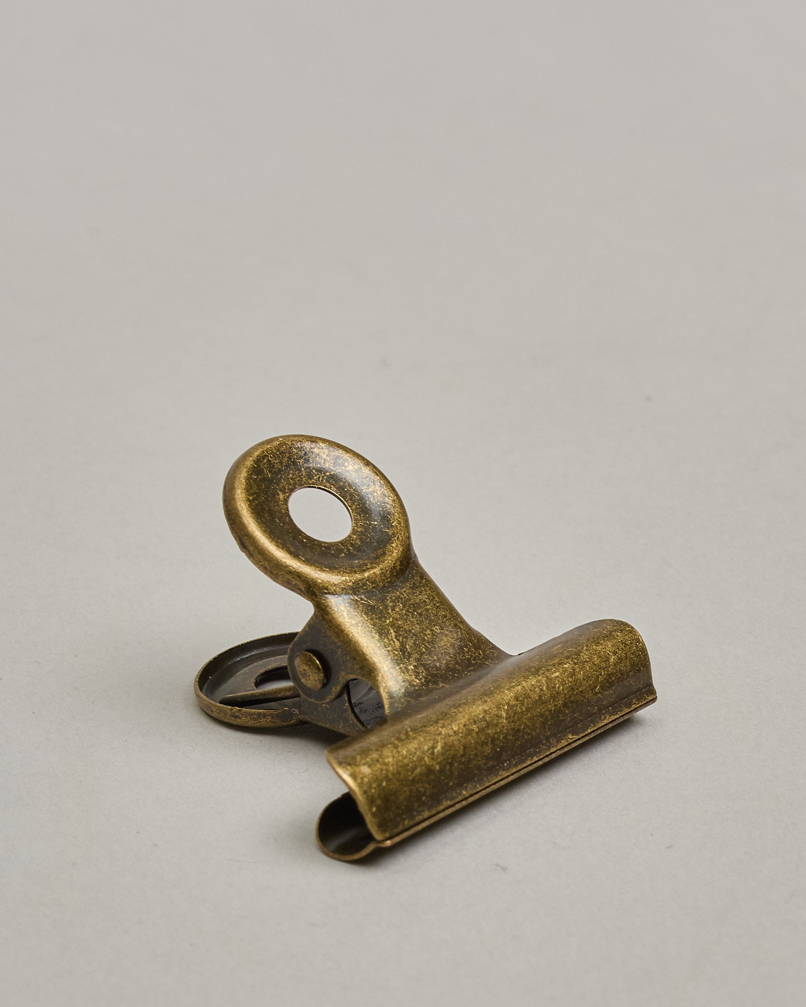 Ein einzelner Metall-Clip in antikem braun mit einem Loch in den Greifarmen an denen man sie oben öffnen kann. #4