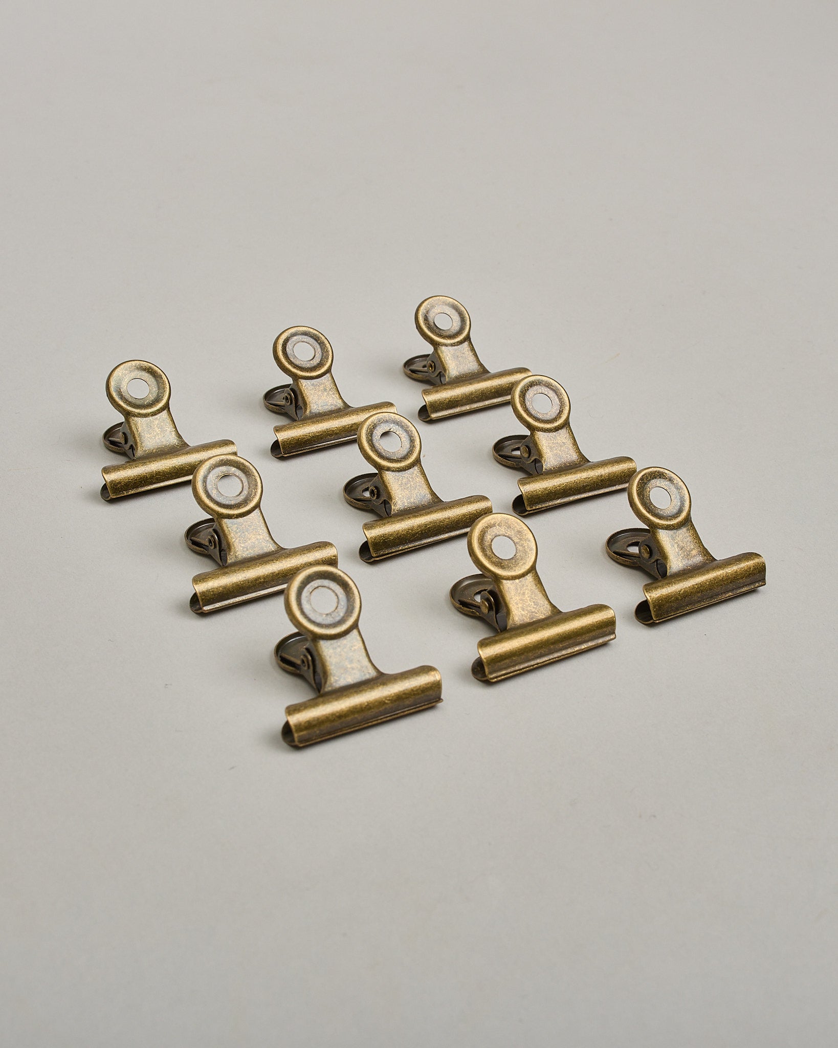 Ein einzelner Metall-Clip in antikem braun mit einem Loch in den Greifarmen an denen man sie oben öffnen kann. #1