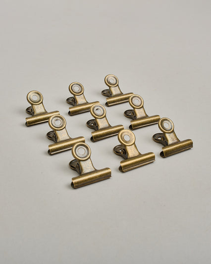 Ein einzelner Metall-Clip in antikem braun mit einem Loch in den Greifarmen an denen man sie oben öffnen kann. #1