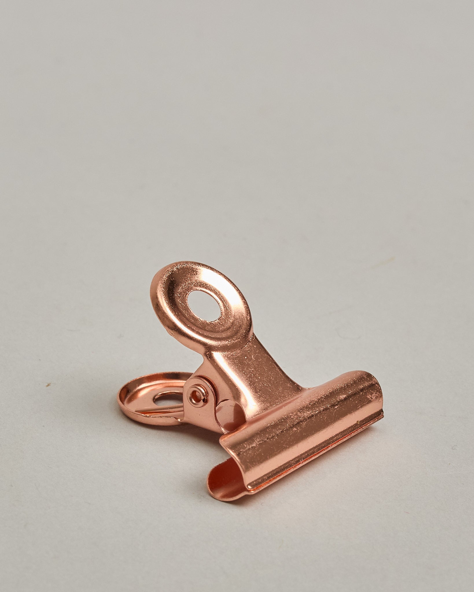 Ein einzelner Metall-Clip in rosé mit einem Loch in den Greifarmen an denen man sie oben öffnen kann. #13