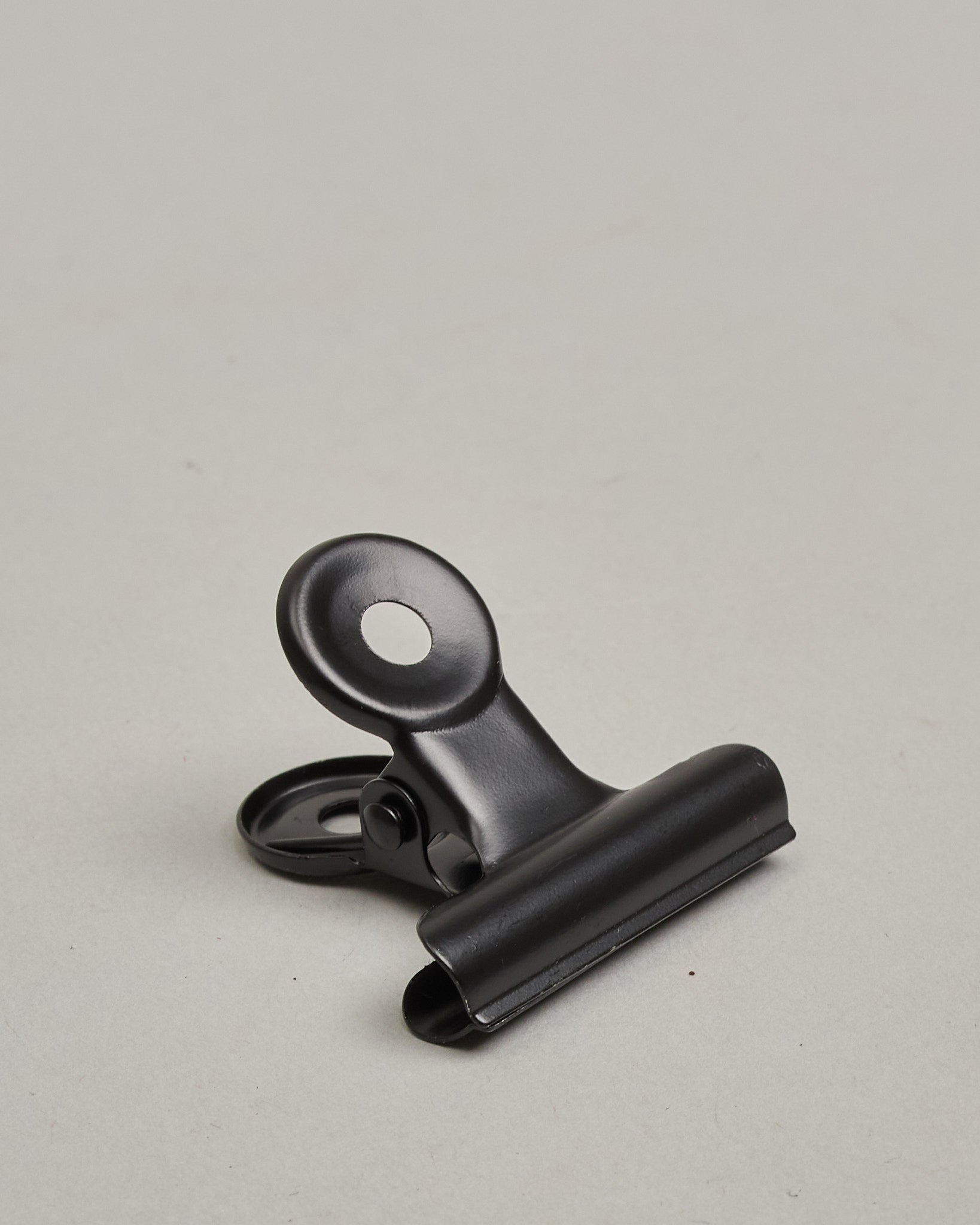 Ein einzelner Metall-Clip in antikem braun mit einem Loch in den Greifarmen an denen man sie oben öffnen kann. #17