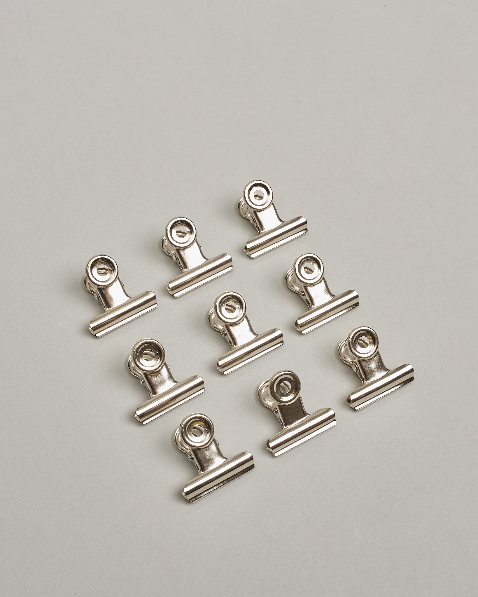 Ein einzelner Metall-Clip in antikem braun mit einem Loch in den Greifarmen an denen man sie oben öffnen kann. #20