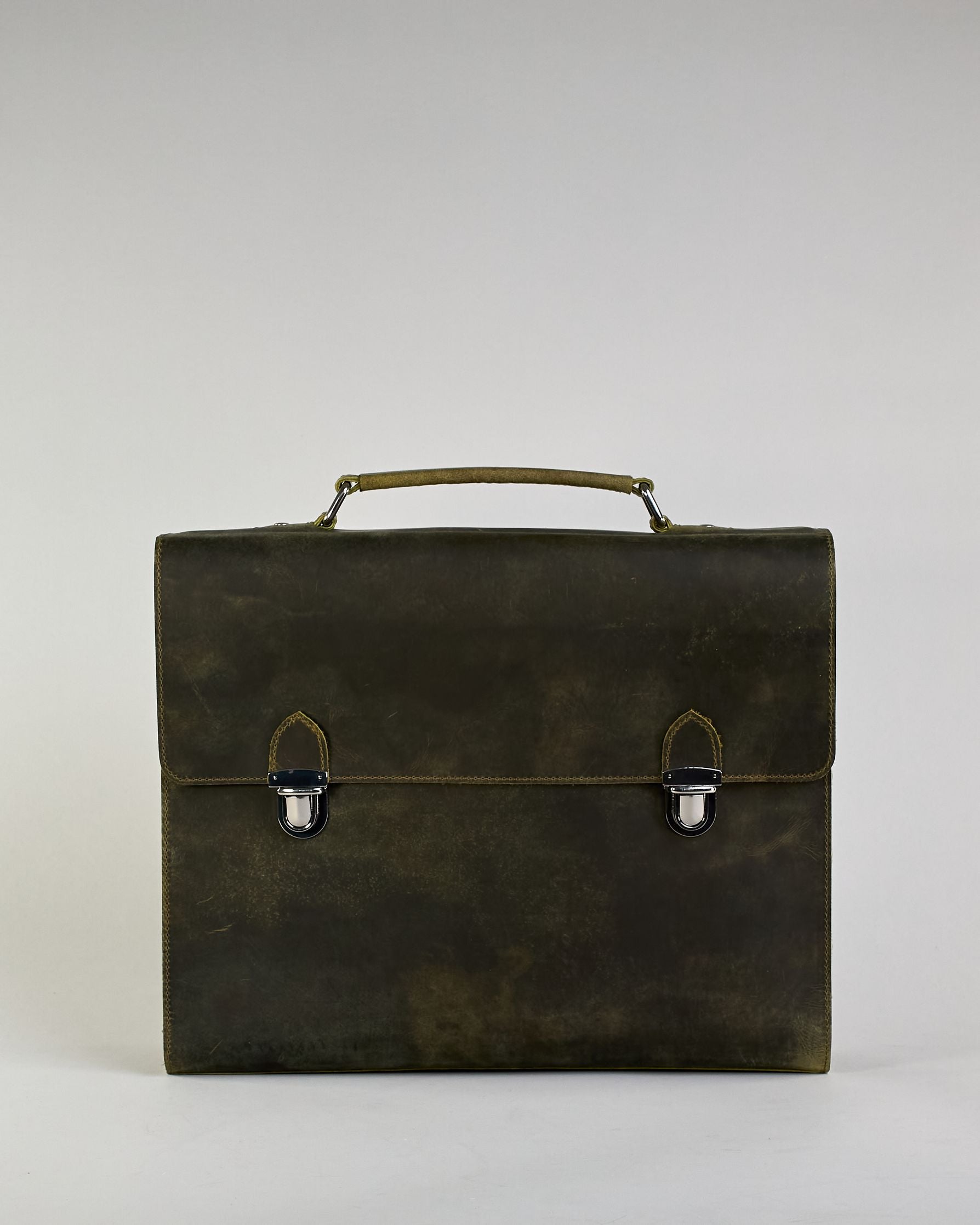 Schwarze Aktentasche aus Hunterleder mit Tragegriff, abnehmbarem Schulterriemen, Metallverschlüssen sowie Innenfächer. Das Lederist anfangs matt und entwickelt mit der Zeit eine individuelle Patina. Logo Prägung unter der Lasche mit zwei Metallverschlüssen in klassischem Schultaschen-Stil. #47