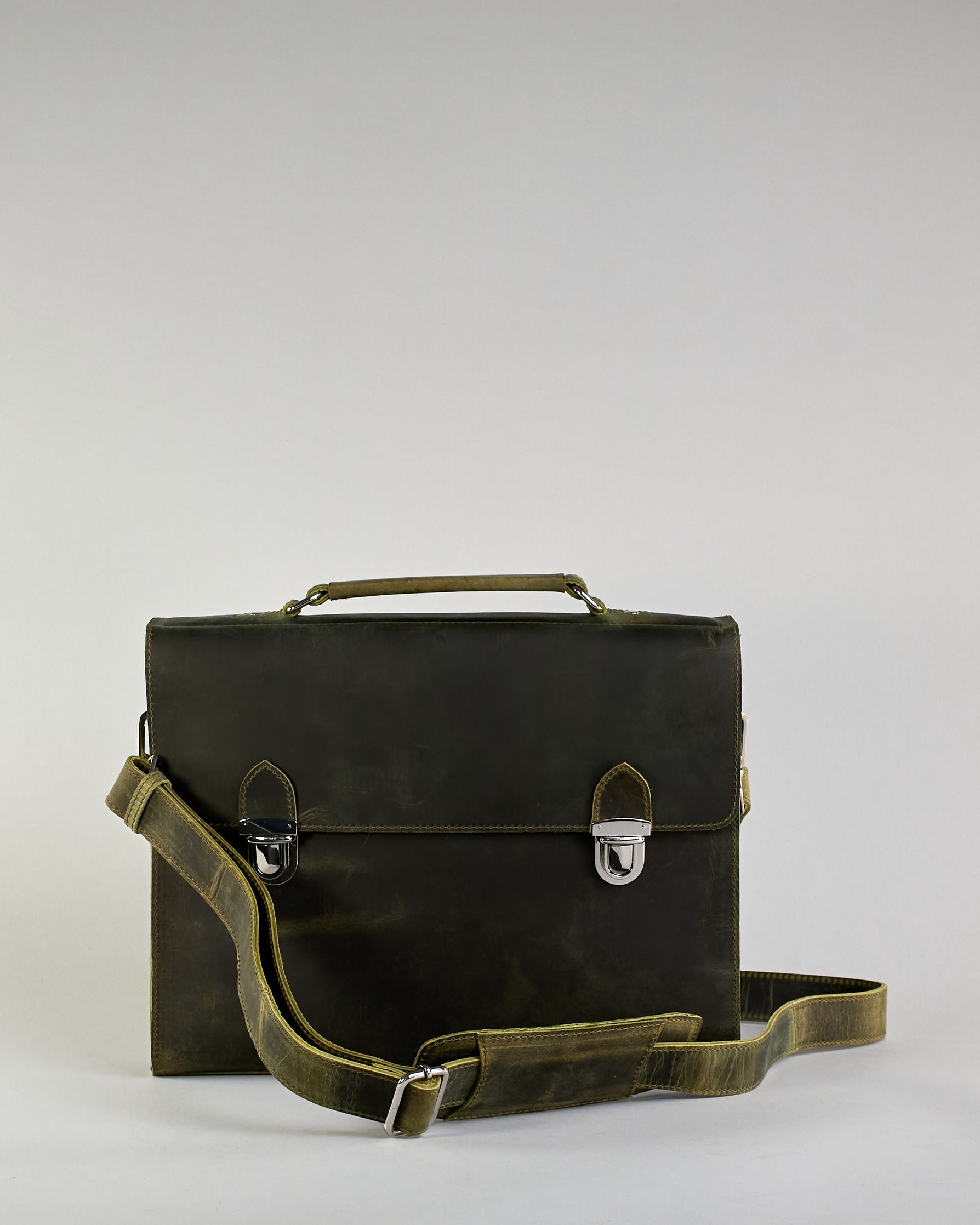 Schwarze Aktentasche aus Hunterleder mit Tragegriff, abnehmbarem Schulterriemen, Metallverschlüssen sowie Innenfächer. Das Lederist anfangs matt und entwickelt mit der Zeit eine individuelle Patina. Logo Prägung unter der Lasche mit zwei Metallverschlüssen in klassischem Schultaschen-Stil. #15