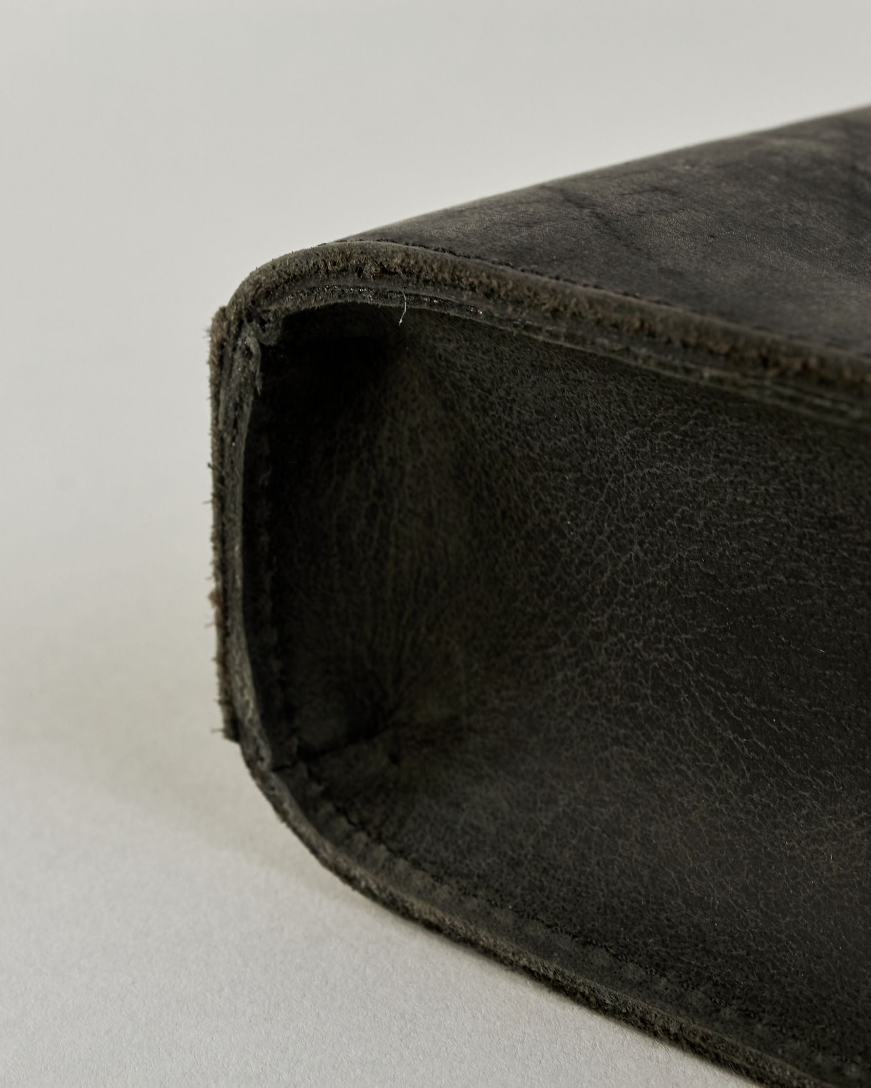 Schwarze Aktentasche aus Hunterleder mit Tragegriff, abnehmbarem Schulterriemen, Metallverschlüssen sowie Innenfächer. Das Lederist anfangs matt und entwickelt mit der Zeit eine individuelle Patina. Logo Prägung unter der Lasche mit zwei Metallverschlüssen in klassischem Schultaschen-Stil. #19