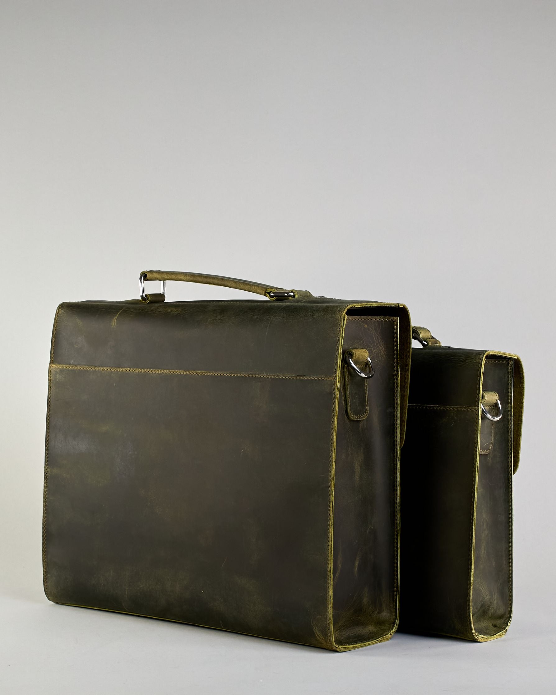 Schwarze Aktentasche aus Hunterleder mit Tragegriff, abnehmbarem Schulterriemen, Metallverschlüssen sowie Innenfächer. Das Lederist anfangs matt und entwickelt mit der Zeit eine individuelle Patina. Logo Prägung unter der Lasche mit zwei Metallverschlüssen in klassischem Schultaschen-Stil. #53