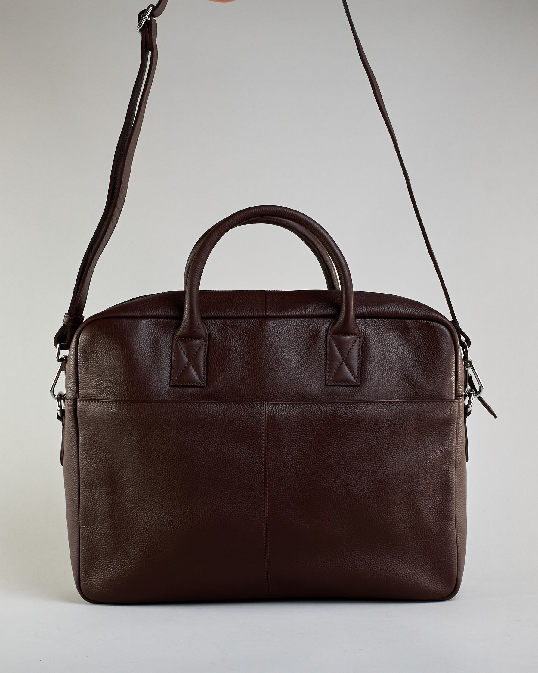 Schlichte schwarze Leder-Aktentasche mit zwei kurzen fixen Lederhänkeln und einem Zippverschluss oben. Trolleylasche und kleine Logo Prägung "Herzilein-Wien" auf der Rückseite. #8