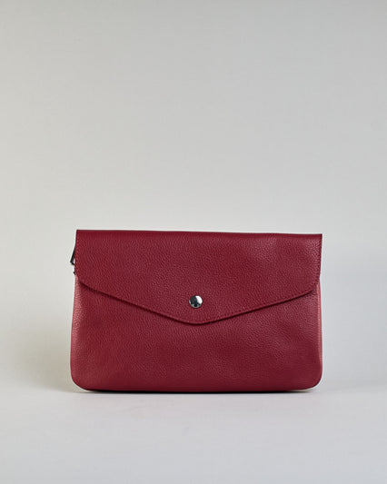 Einfärbige kleine Crossbody-Tasche aus genarbtem Rindleder mit Umschlaglasche und silbernem Druckknopf. Die Tasche enthält innen ein Zippfach, ein offenes Fach sowie ein schmales Zwischenfach. Auf der Rückseite ist eine Logoprägung "Herzilein-Wien" #1