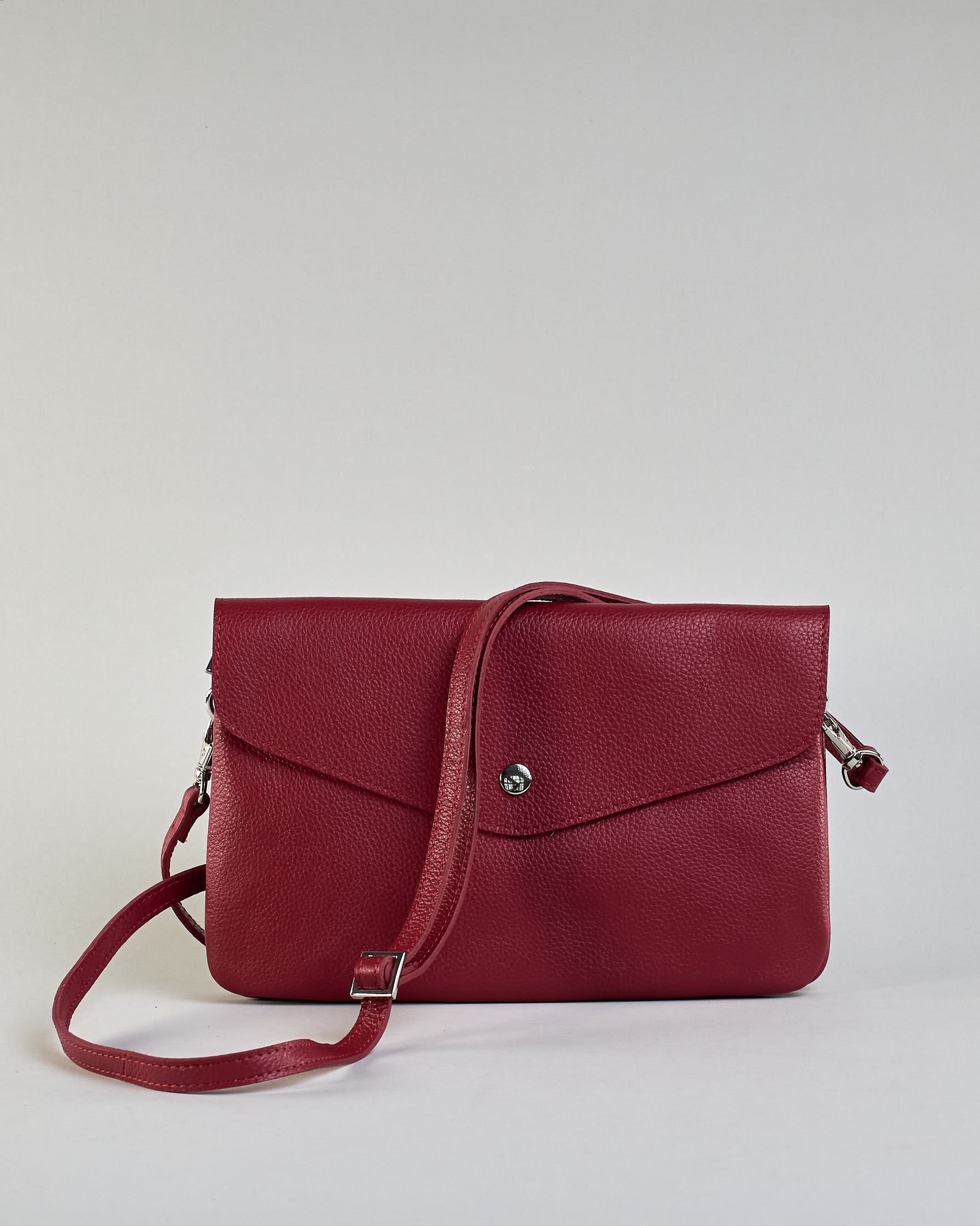 Einfärbige kleine Crossbody-Tasche aus genarbtem Rindleder mit Umschlaglasche und silbernem Druckknopf. Die Tasche enthält innen ein Zippfach, ein offenes Fach sowie ein schmales Zwischenfach. Auf der Rückseite ist eine Logoprägung "Herzilein-Wien" #4