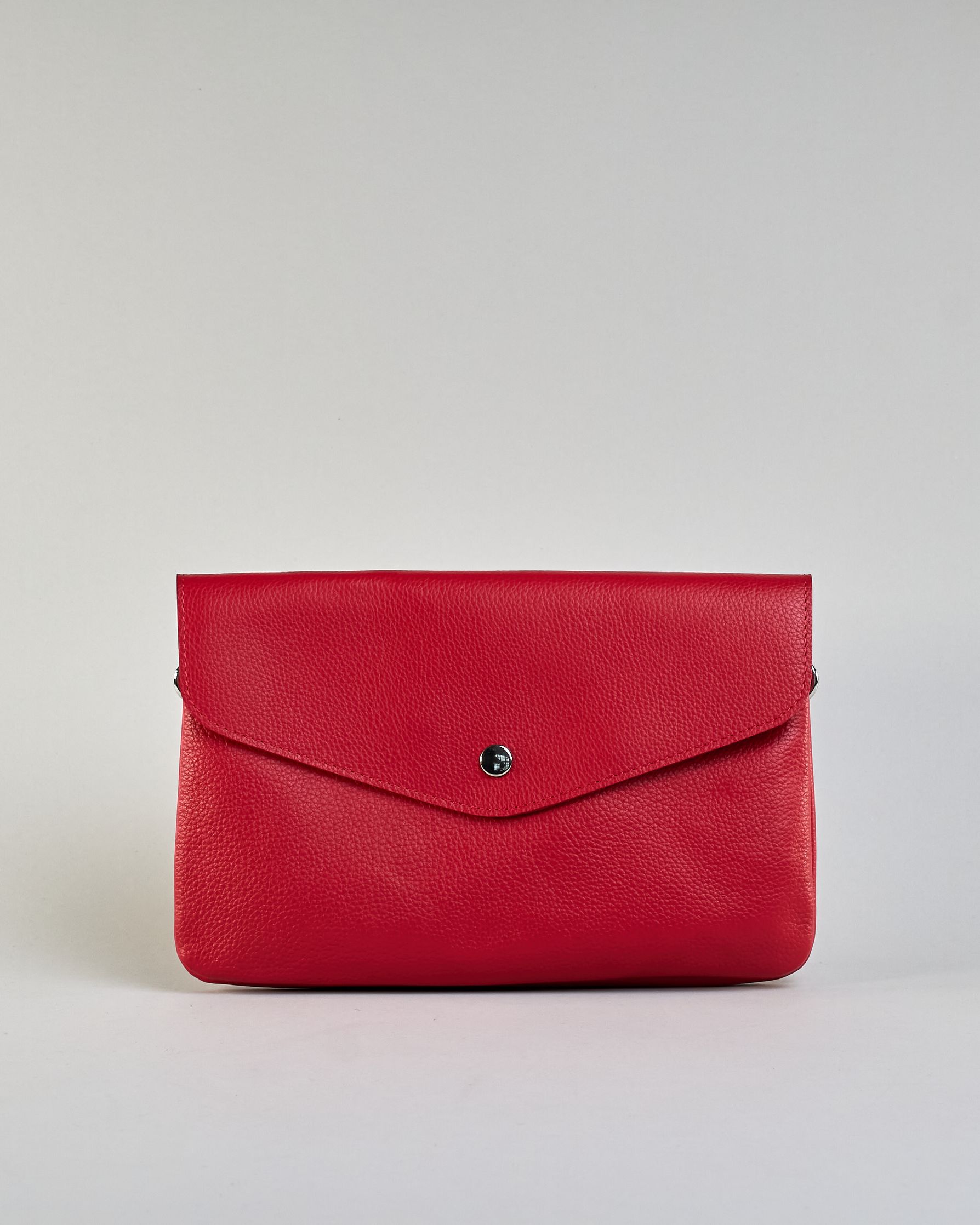 Einfärbige kleine Crossbody-Tasche aus genarbtem Rindleder mit Umschlaglasche und silbernem Druckknopf. Die Tasche enthält innen ein Zippfach, ein offenes Fach sowie ein schmales Zwischenfach. Auf der Rückseite ist eine Logoprägung "Herzilein-Wien" #13