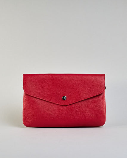 Einfärbige kleine Crossbody-Tasche aus genarbtem Rindleder mit Umschlaglasche und silbernem Druckknopf. Die Tasche enthält innen ein Zippfach, ein offenes Fach sowie ein schmales Zwischenfach. Auf der Rückseite ist eine Logoprägung "Herzilein-Wien" #13