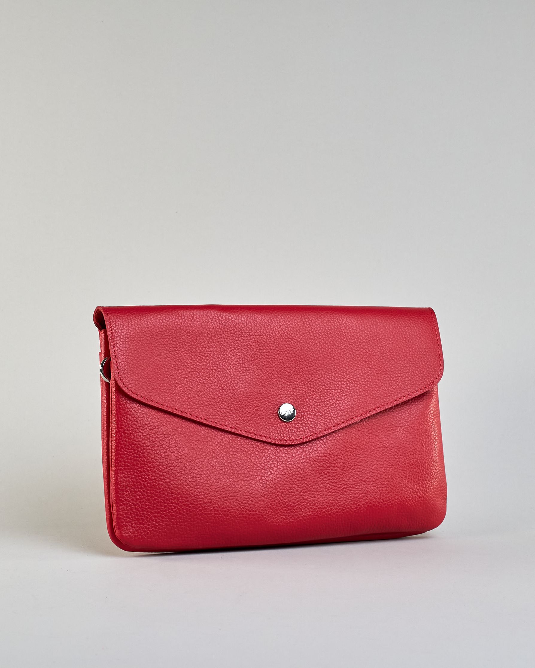 Einfärbige kleine Crossbody-Tasche aus genarbtem Rindleder mit Umschlaglasche und silbernem Druckknopf. Die Tasche enthält innen ein Zippfach, ein offenes Fach sowie ein schmales Zwischenfach. Auf der Rückseite ist eine Logoprägung "Herzilein-Wien" #14