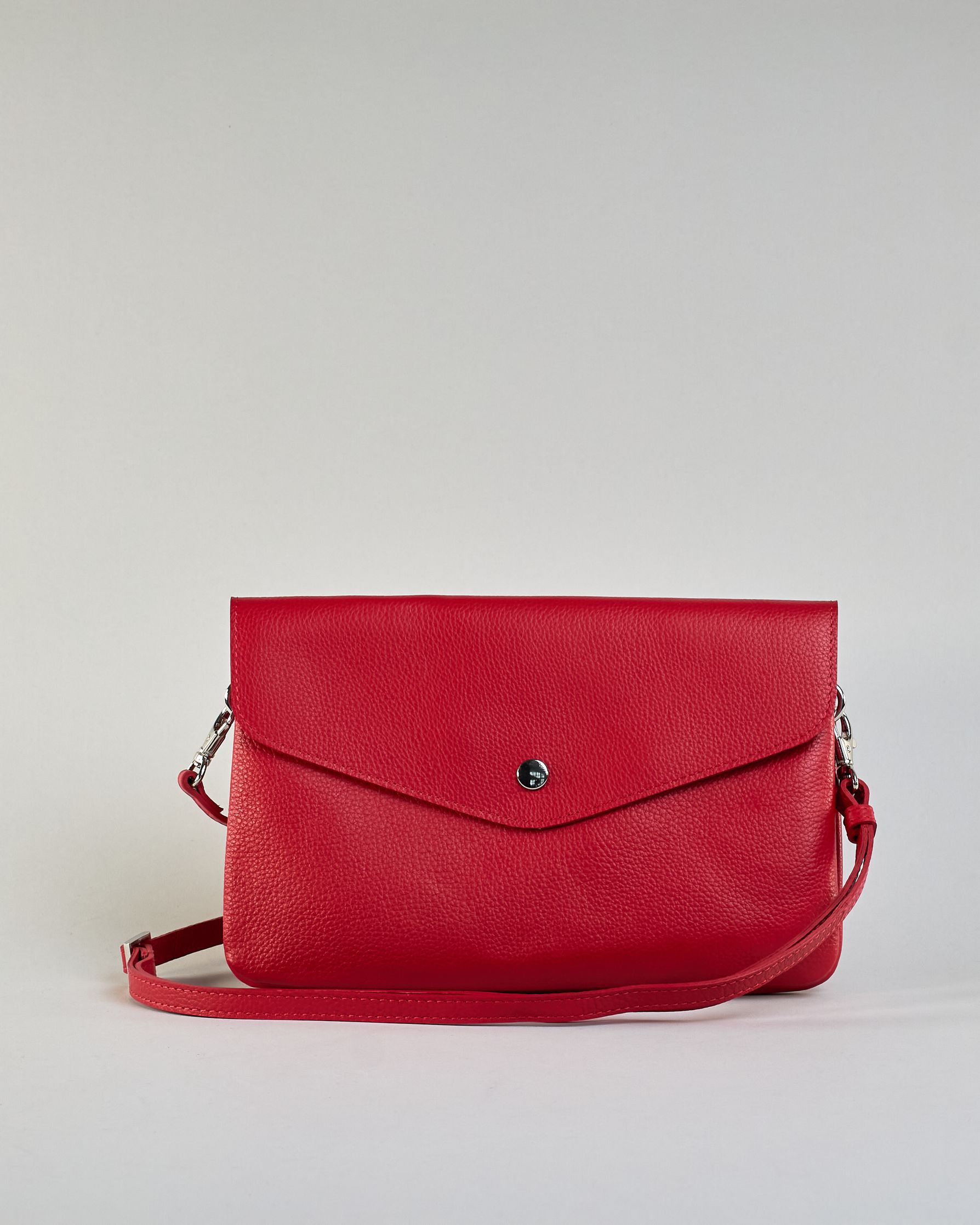 Einfärbige kleine Crossbody-Tasche aus genarbtem Rindleder mit Umschlaglasche und silbernem Druckknopf. Die Tasche enthält innen ein Zippfach, ein offenes Fach sowie ein schmales Zwischenfach. Auf der Rückseite ist eine Logoprägung "Herzilein-Wien" #17