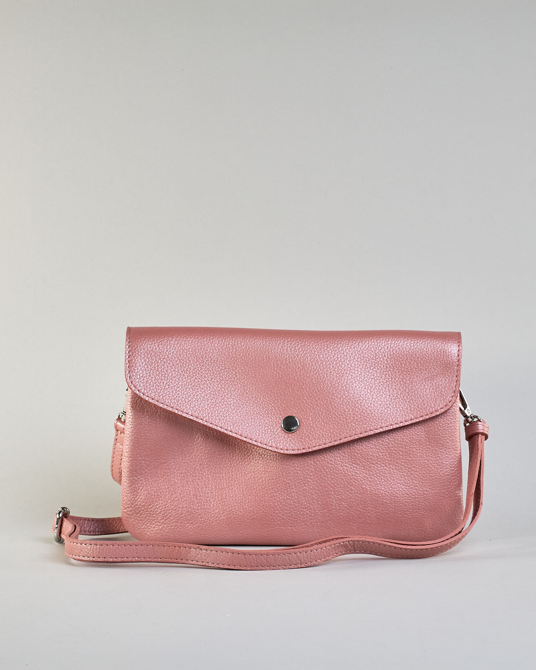 Einfärbige kleine Crossbody-Tasche aus genarbtem Rindleder mit Umschlaglasche und silbernem Druckknopf. Die Tasche enthält innen ein Zippfach, ein offenes Fach sowie ein schmales Zwischenfach. Auf der Rückseite ist eine Logoprägung "Herzilein-Wien" #28