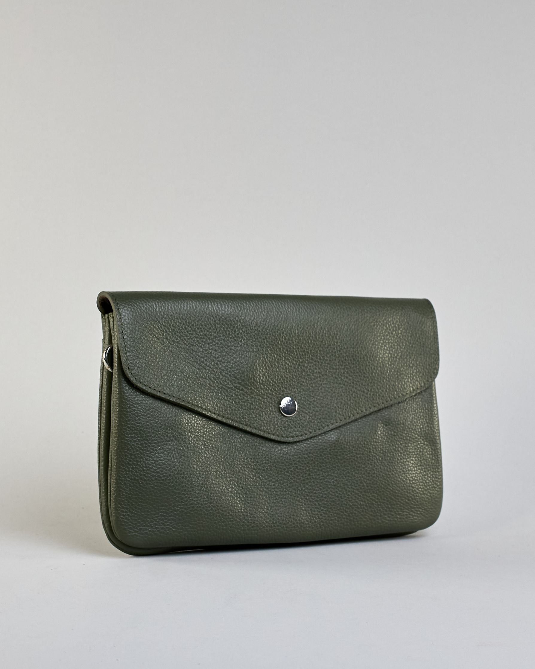 Einfärbige kleine Crossbody-Tasche aus genarbtem Rindleder mit Umschlaglasche und silbernem Druckknopf. Die Tasche enthält innen ein Zippfach, ein offenes Fach sowie ein schmales Zwischenfach. Auf der Rückseite ist eine Logoprägung "Herzilein-Wien" #37