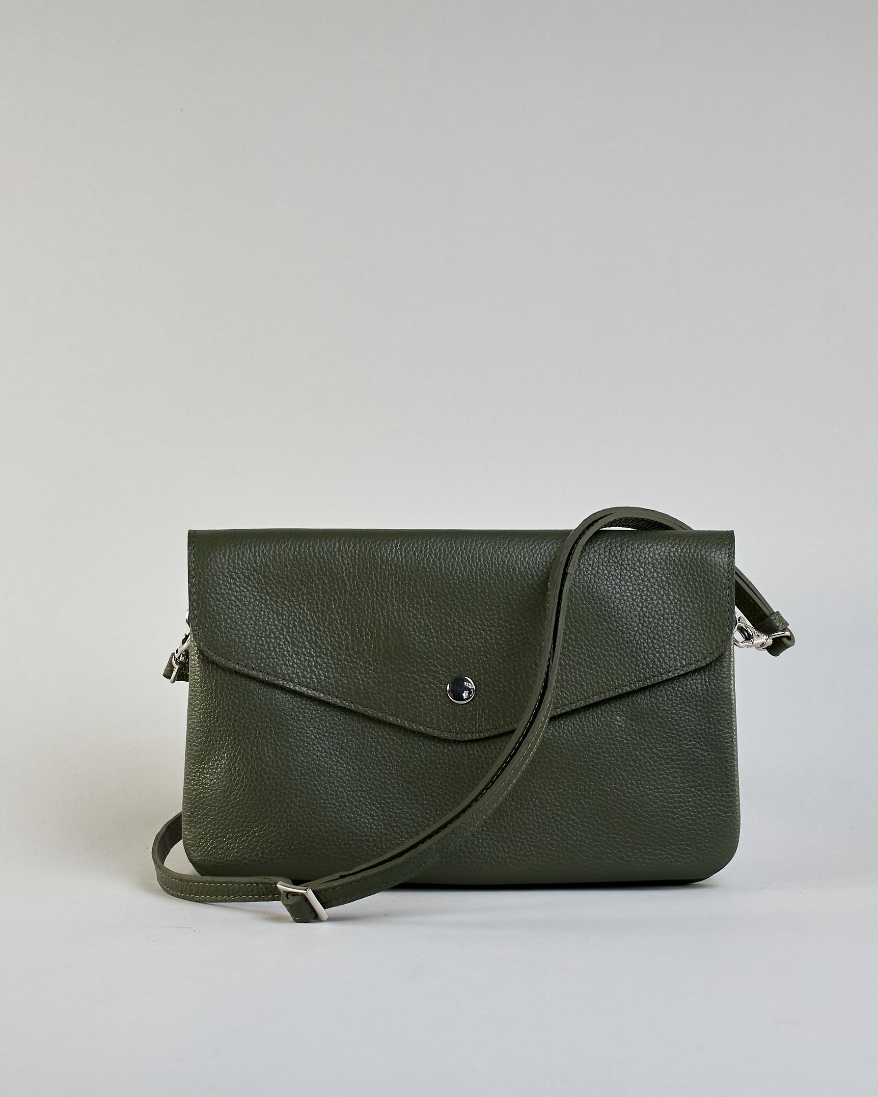 Einfärbige kleine Crossbody-Tasche aus genarbtem Rindleder mit Umschlaglasche und silbernem Druckknopf. Die Tasche enthält innen ein Zippfach, ein offenes Fach sowie ein schmales Zwischenfach. Auf der Rückseite ist eine Logoprägung "Herzilein-Wien" #39