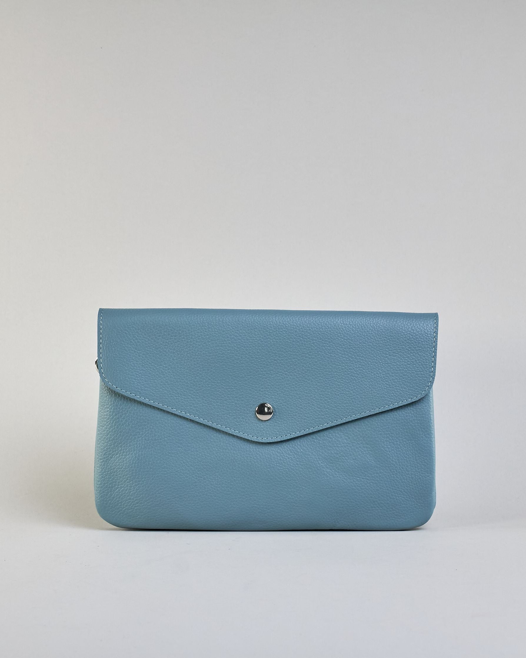 Einfärbige kleine Crossbody-Tasche aus genarbtem Rindleder mit Umschlaglasche und silbernem Druckknopf. Die Tasche enthält innen ein Zippfach, ein offenes Fach sowie ein schmales Zwischenfach. Auf der Rückseite ist eine Logoprägung "Herzilein-Wien" #41