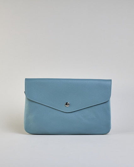 Einfärbige kleine Crossbody-Tasche aus genarbtem Rindleder mit Umschlaglasche und silbernem Druckknopf. Die Tasche enthält innen ein Zippfach, ein offenes Fach sowie ein schmales Zwischenfach. Auf der Rückseite ist eine Logoprägung "Herzilein-Wien" #41