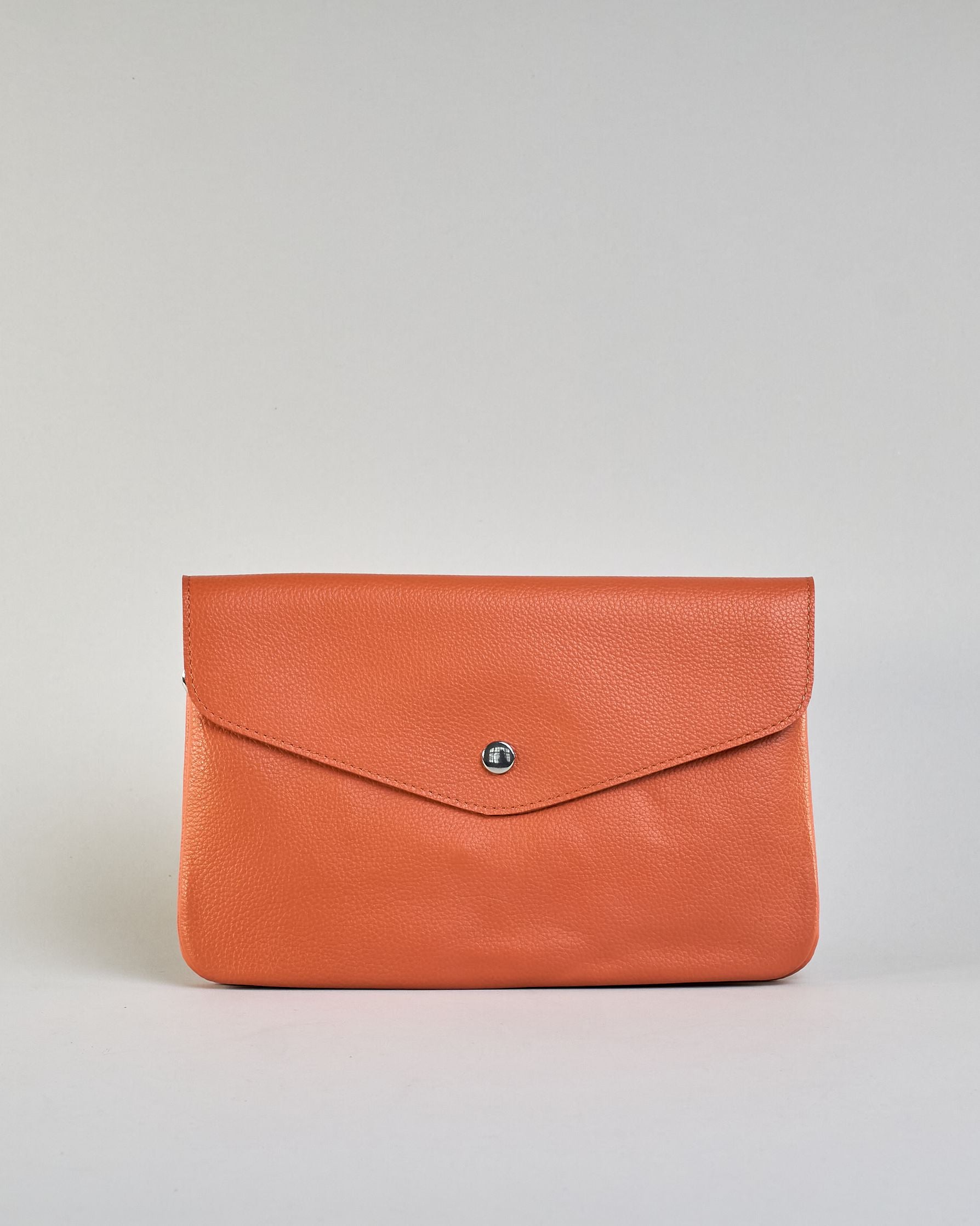 Einfärbige kleine Crossbody-Tasche aus genarbtem Rindleder mit Umschlaglasche und silbernem Druckknopf. Die Tasche enthält innen ein Zippfach, ein offenes Fach sowie ein schmales Zwischenfach. Auf der Rückseite ist eine Logoprägung "Herzilein-Wien" #47