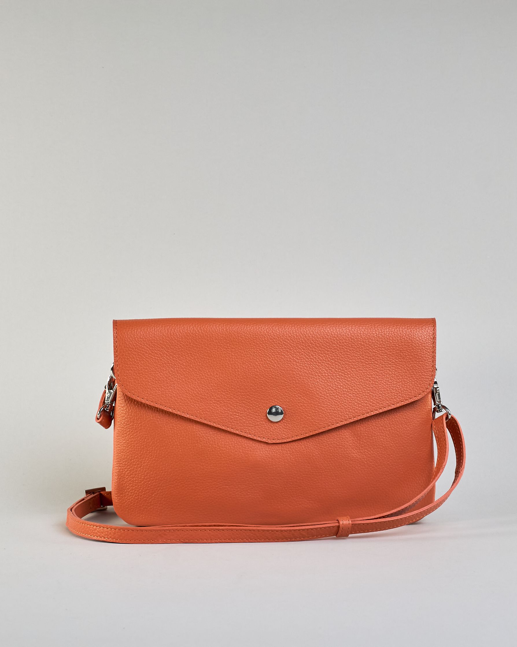 Einfärbige kleine Crossbody-Tasche aus genarbtem Rindleder mit Umschlaglasche und silbernem Druckknopf. Die Tasche enthält innen ein Zippfach, ein offenes Fach sowie ein schmales Zwischenfach. Auf der Rückseite ist eine Logoprägung "Herzilein-Wien" #51