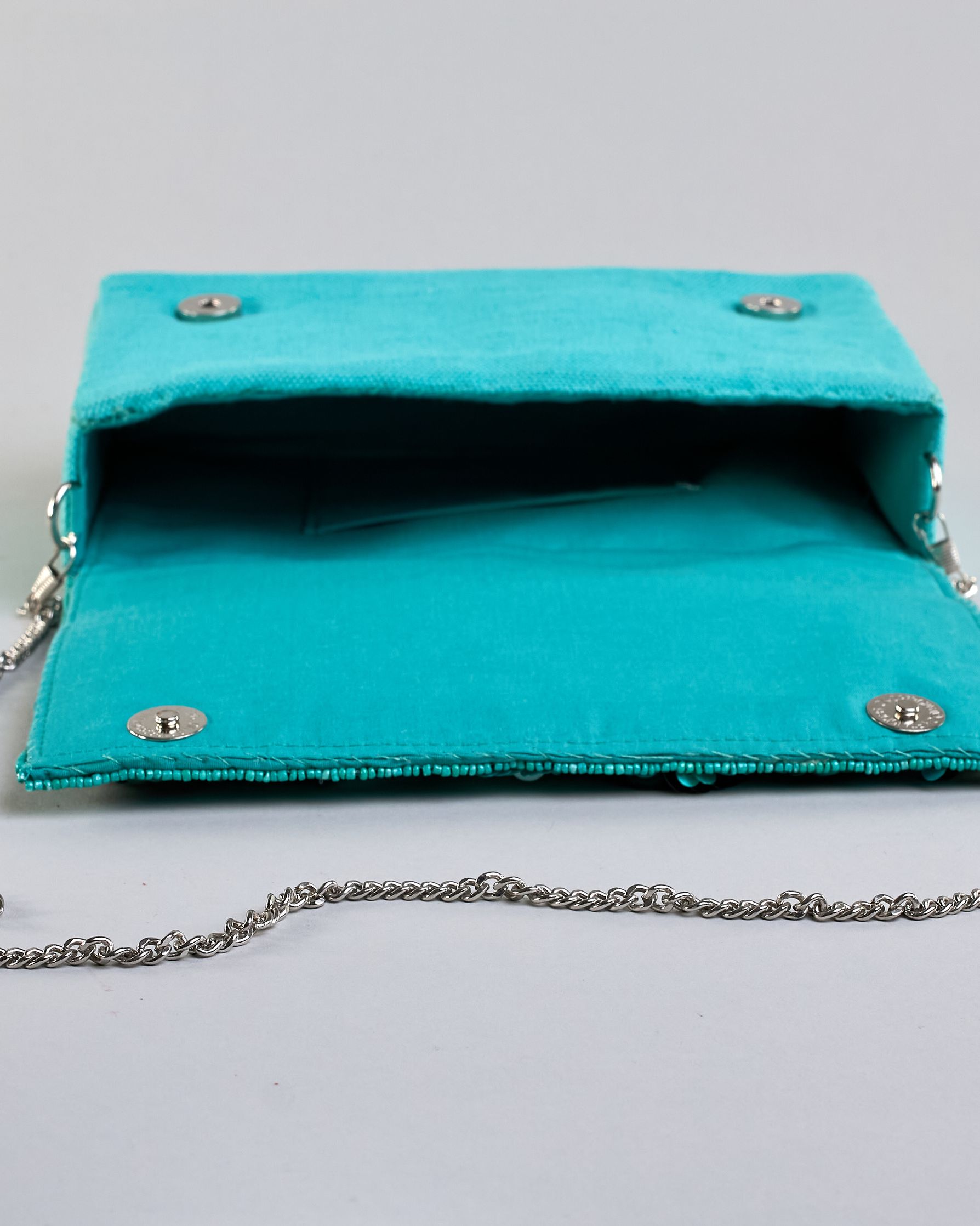 Türkise Crossbodytasche mit bunter Perlen- und Paillettenstickerei in Blumenmotiven und silberner Kette als Schulterriemen. Die Rückseite ist aus einfärbigem türkisen Canvas. #7