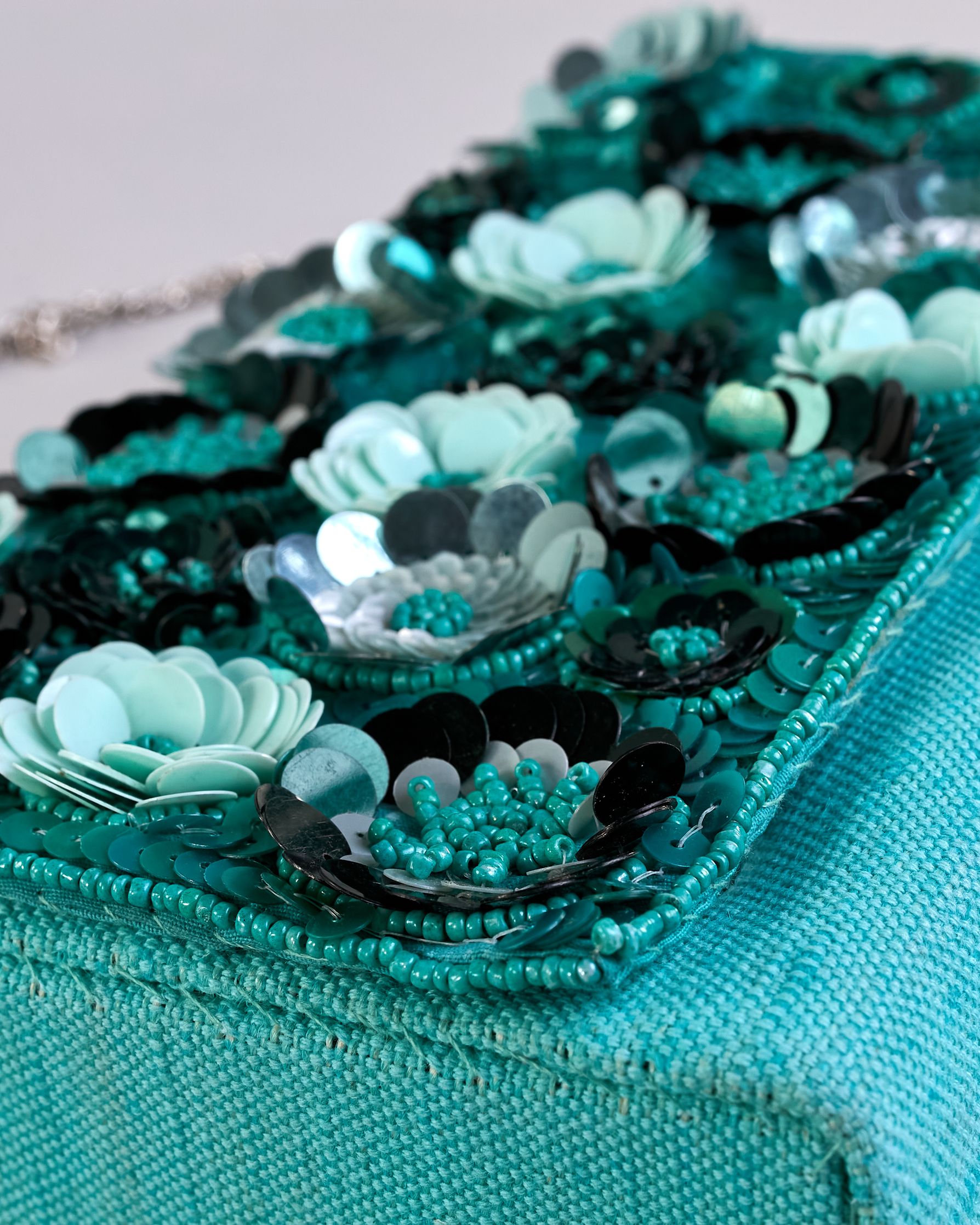 Türkise Crossbodytasche mit bunter Perlen- und Paillettenstickerei in Blumenmotiven und silberner Kette als Schulterriemen. Die Rückseite ist aus einfärbigem türkisen Canvas. #8
