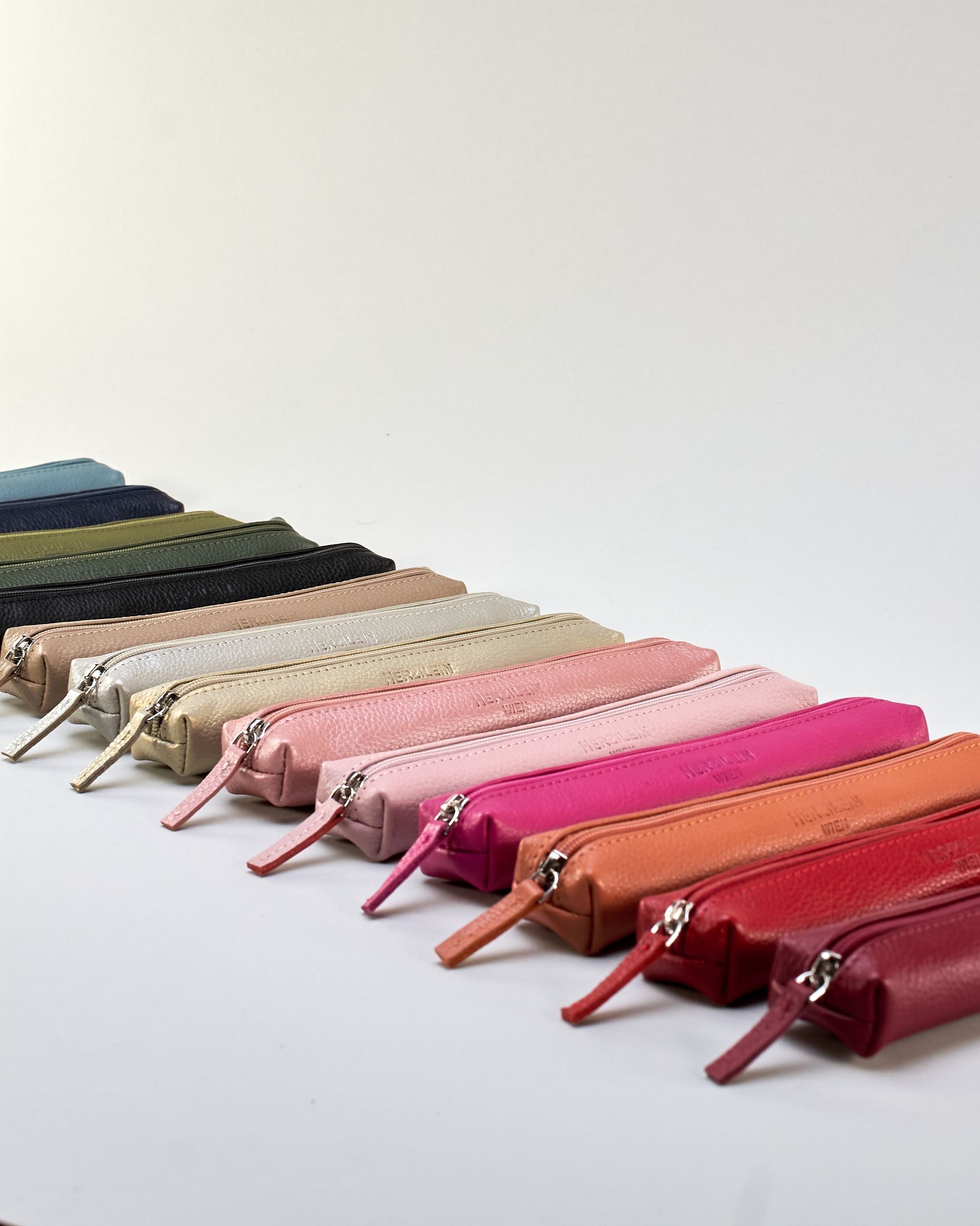 Schlankes, oranges Federpenal aus Rindleder mit silbernem Reißverschluss.