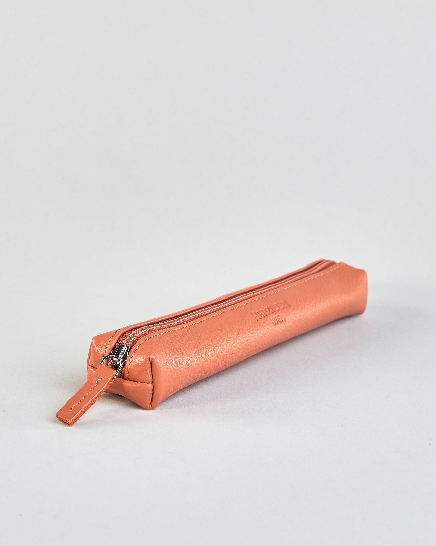 Schlankes, oranges Federpenal aus Rindleder mit silbernem Reißverschluss.