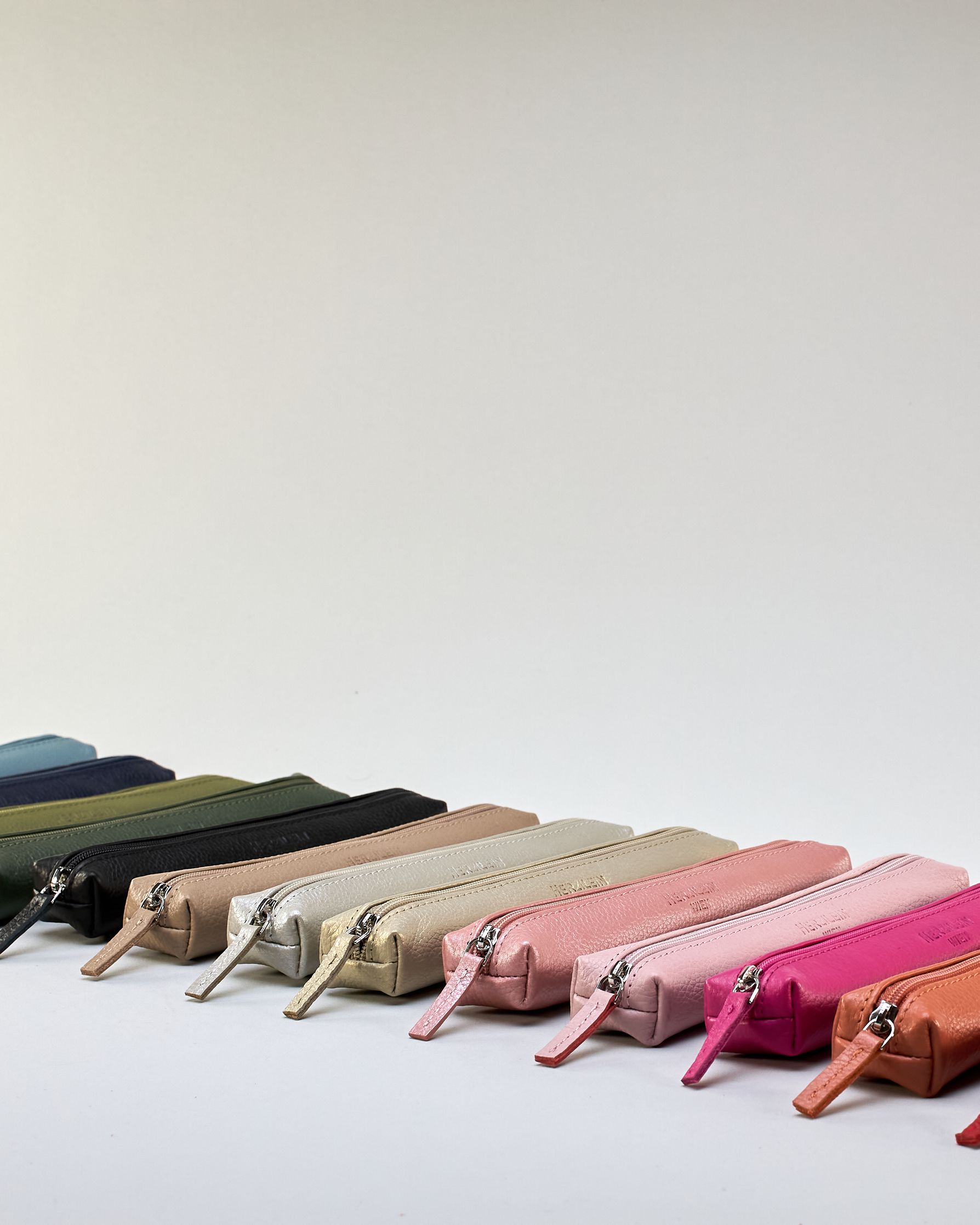 Schlankes, oranges Federpenal aus Rindleder mit silbernem Reißverschluss.