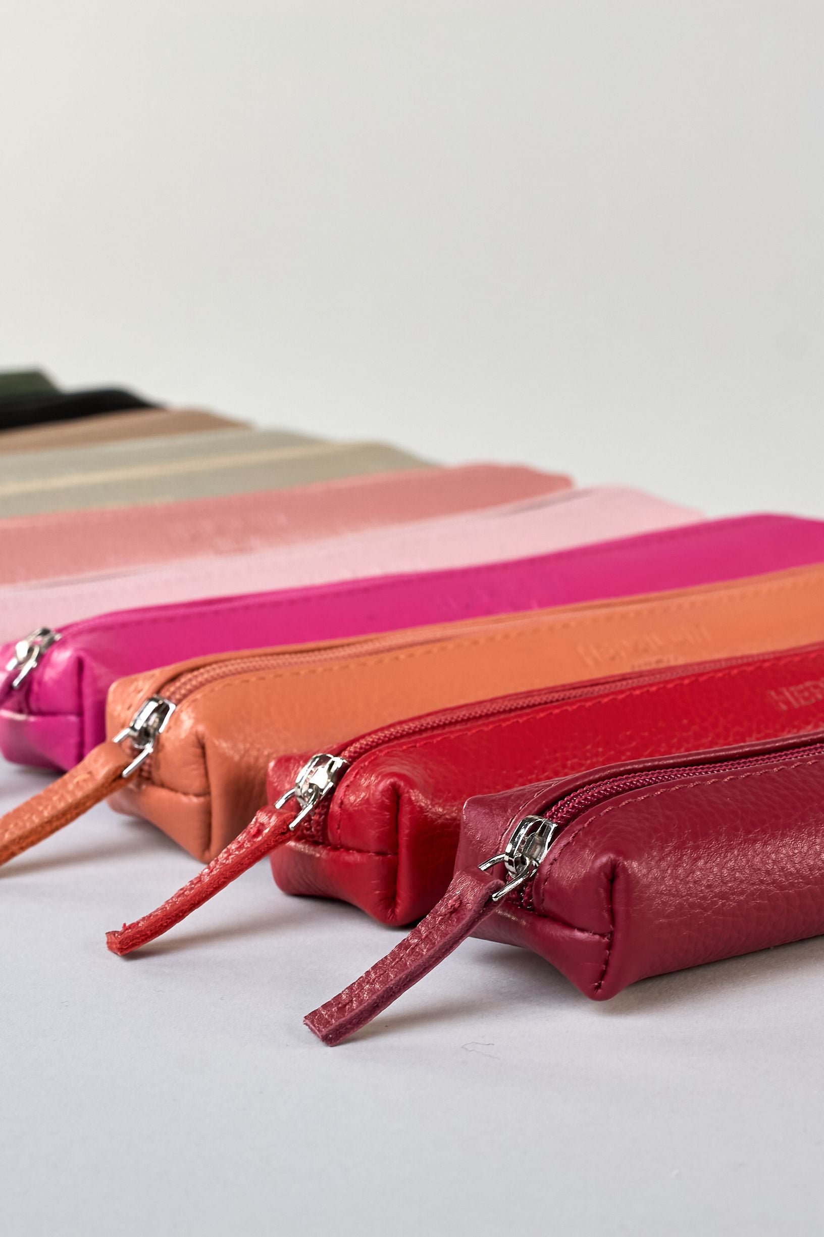 Schlankes, oranges Federpenal aus Rindleder mit silbernem Reißverschluss.